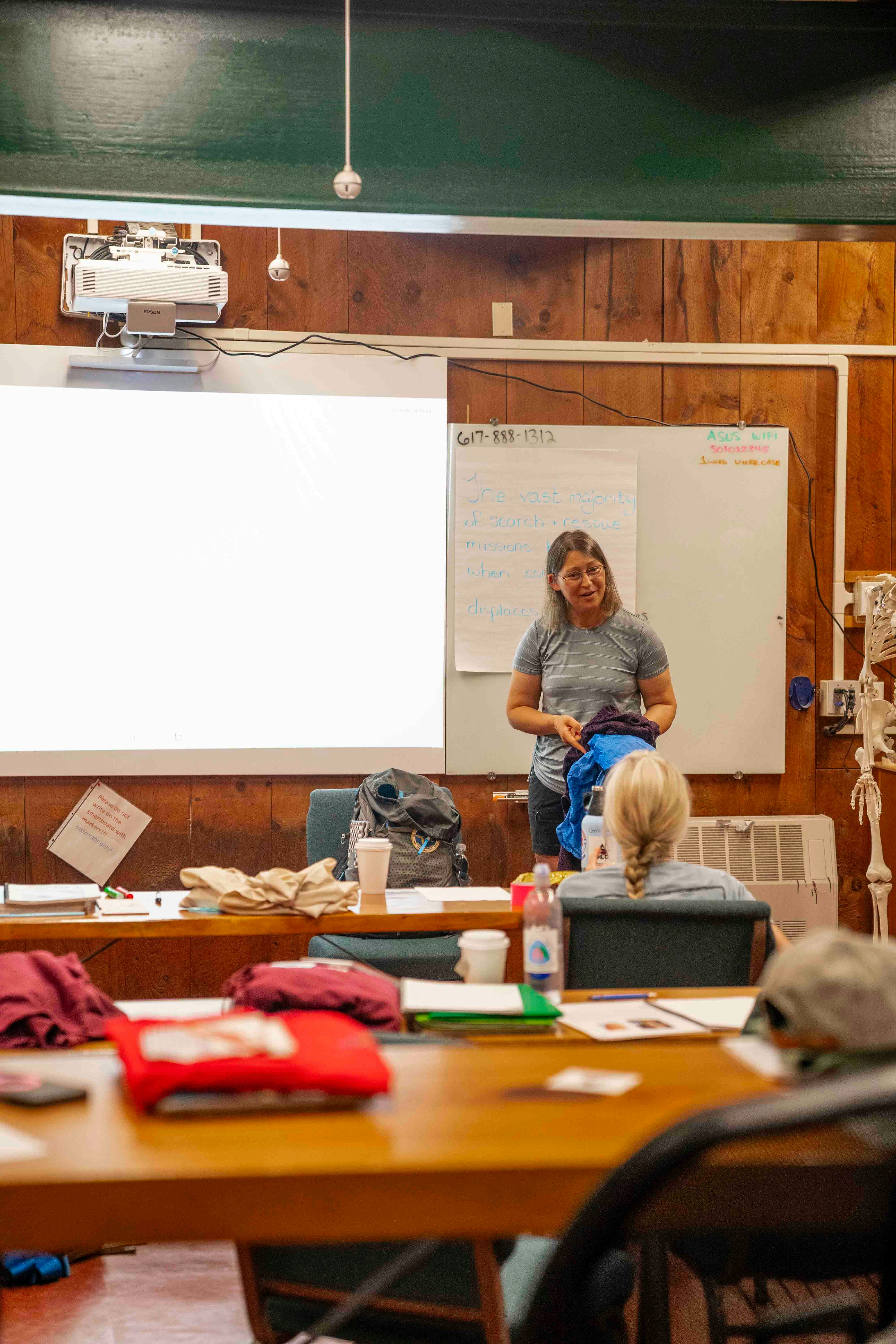 Woman presenting to class with whiteboard and projector