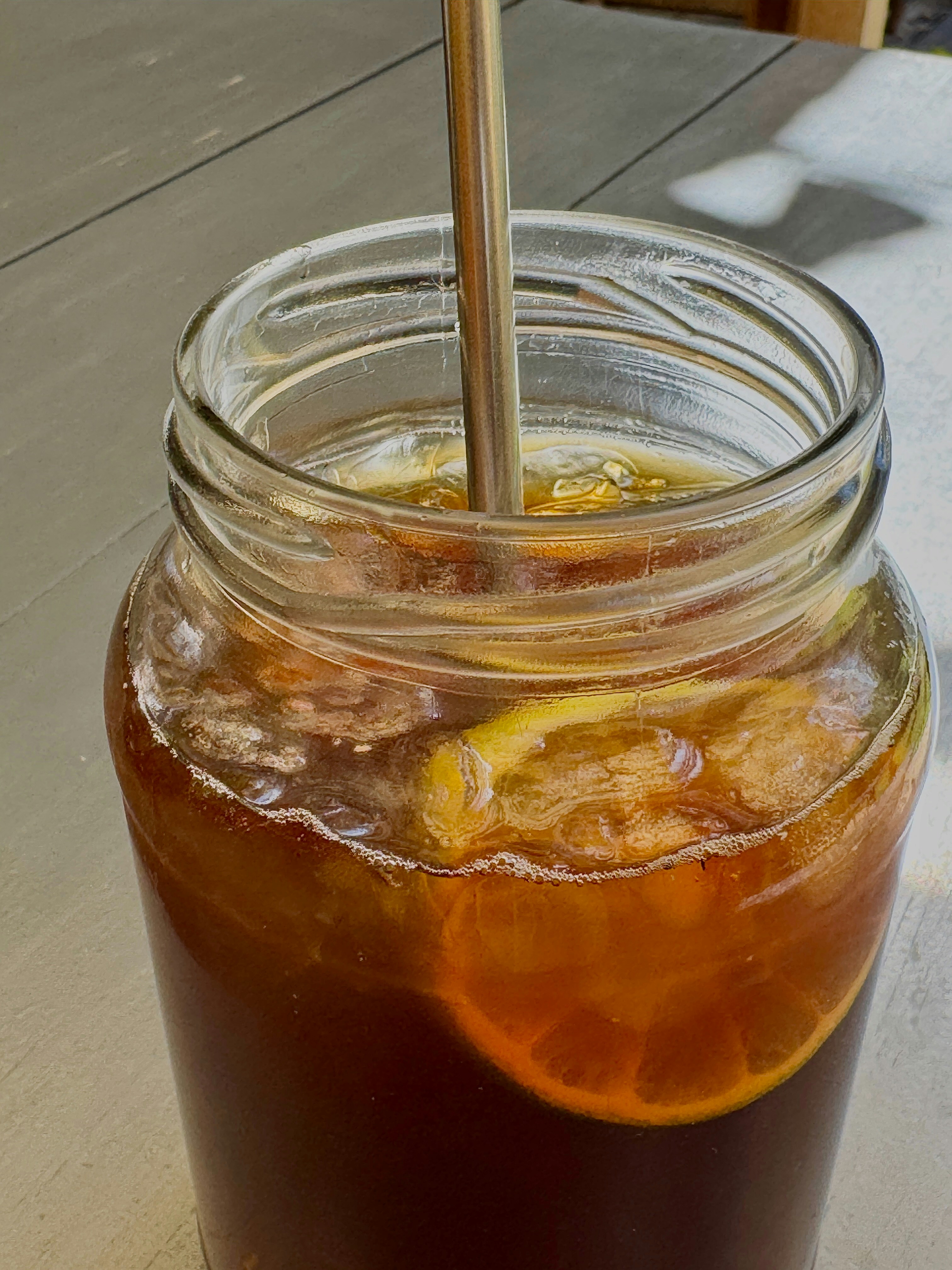 Glass jar filled with iced tea and lemon slices