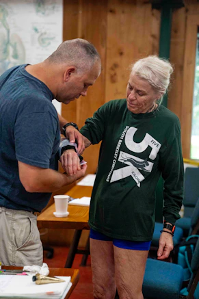 Man applies medical tape to woman's arm