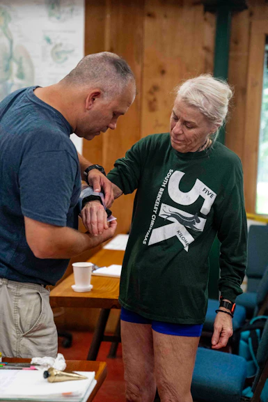 Man applies medical tape to woman's arm