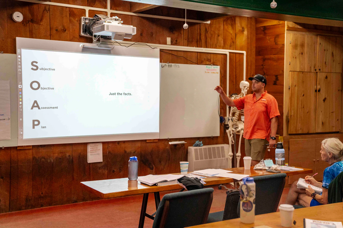 A presenter at a whiteboard leading a group training session
