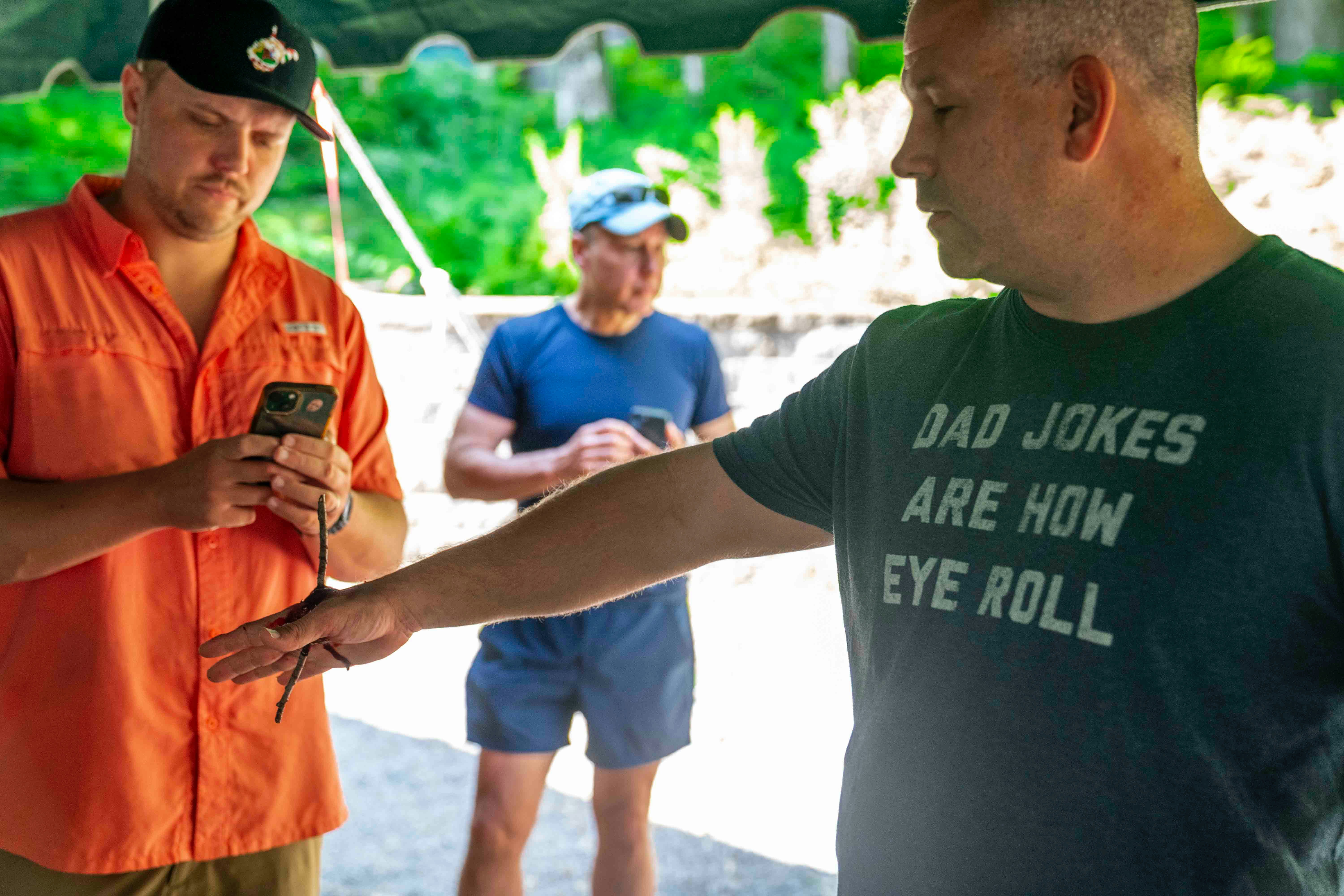 Man shows small reptile to intrigued onlookers