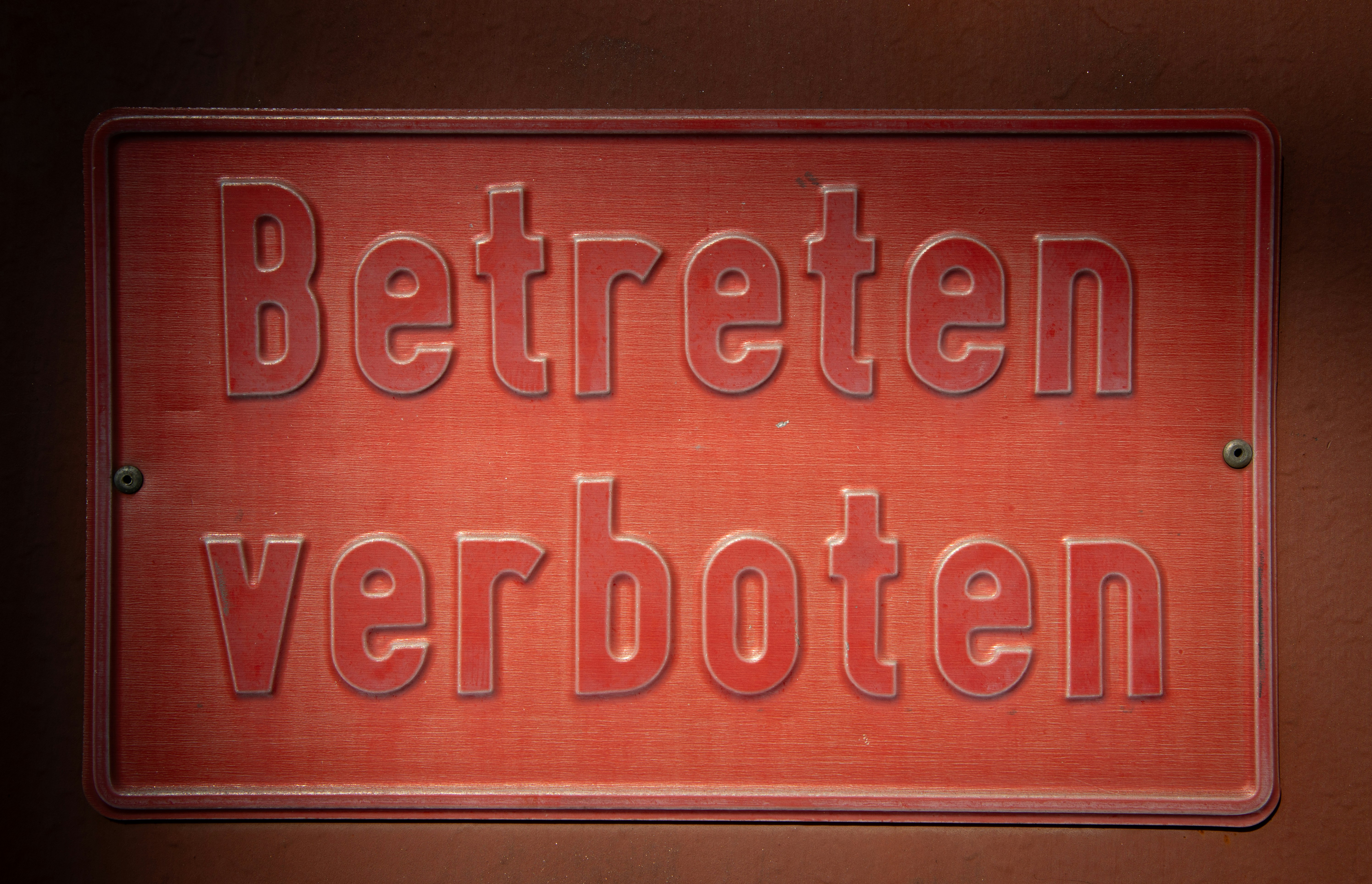 Red sign with embossed german text 'betreten verboten'