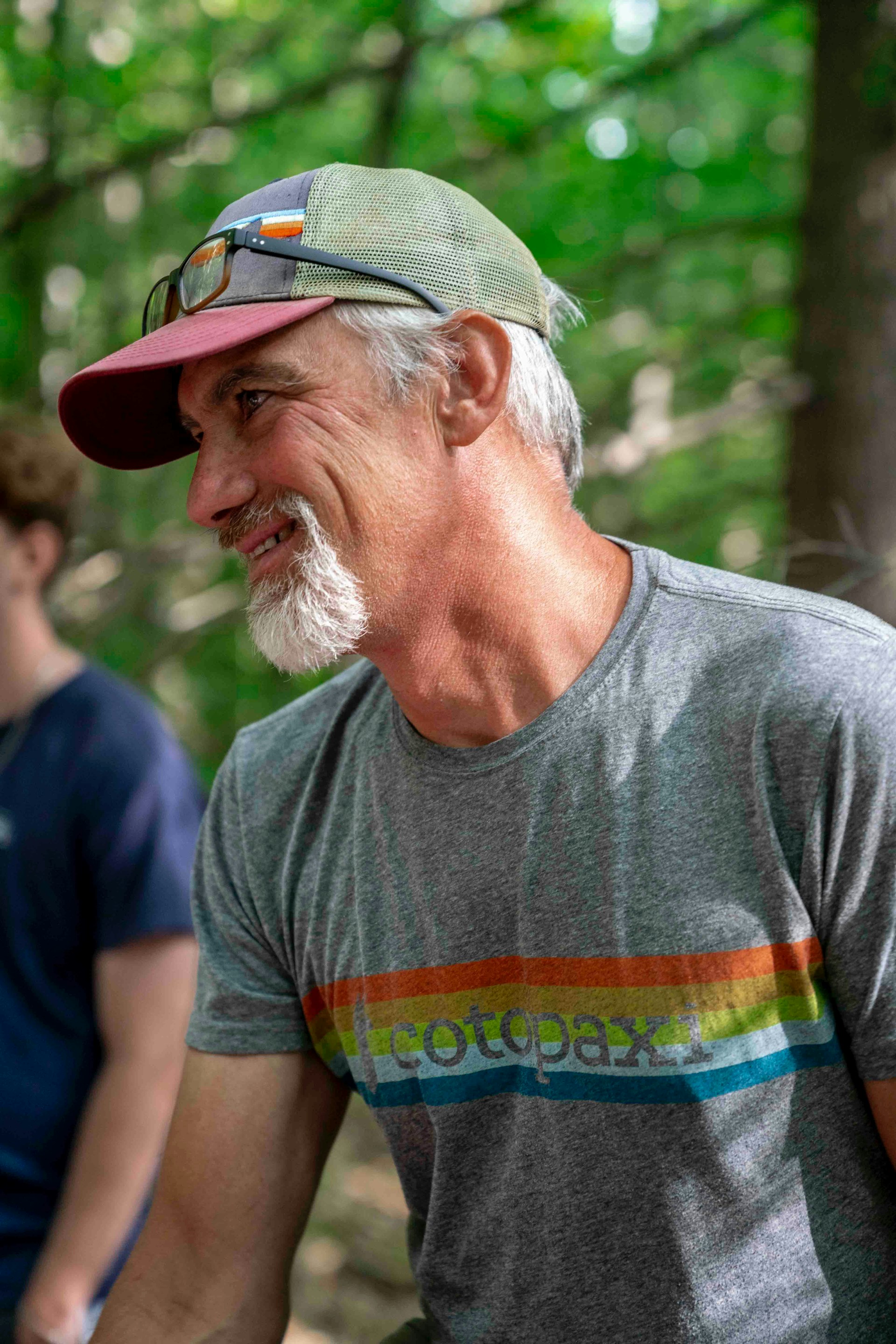 Man with gray beard wearing a baseball cap and t-shirt