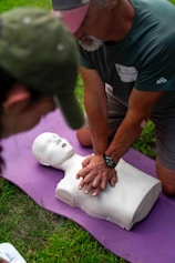 Man practices cpr on a training dummy outdoors