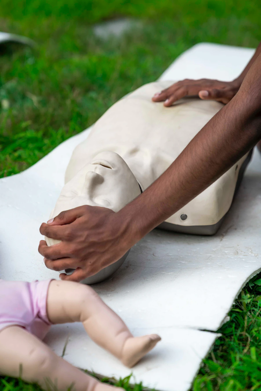 Hands practicing CPR on a training dummy