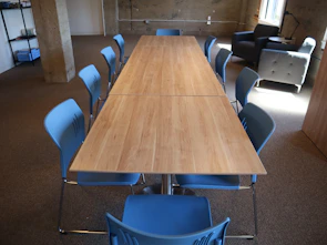 Long wooden table with blue chairs in a room