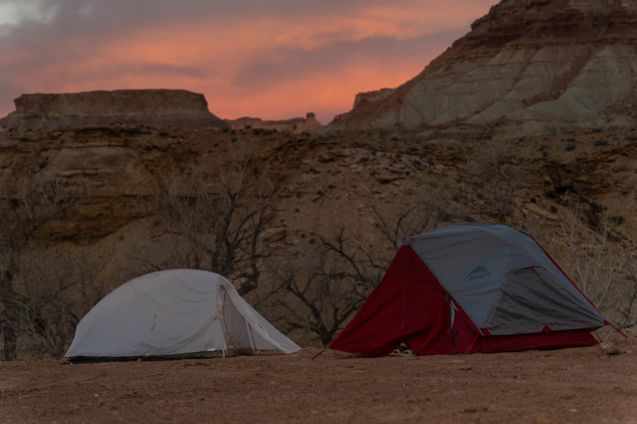 Two tents at rocky desert canyon sunset
