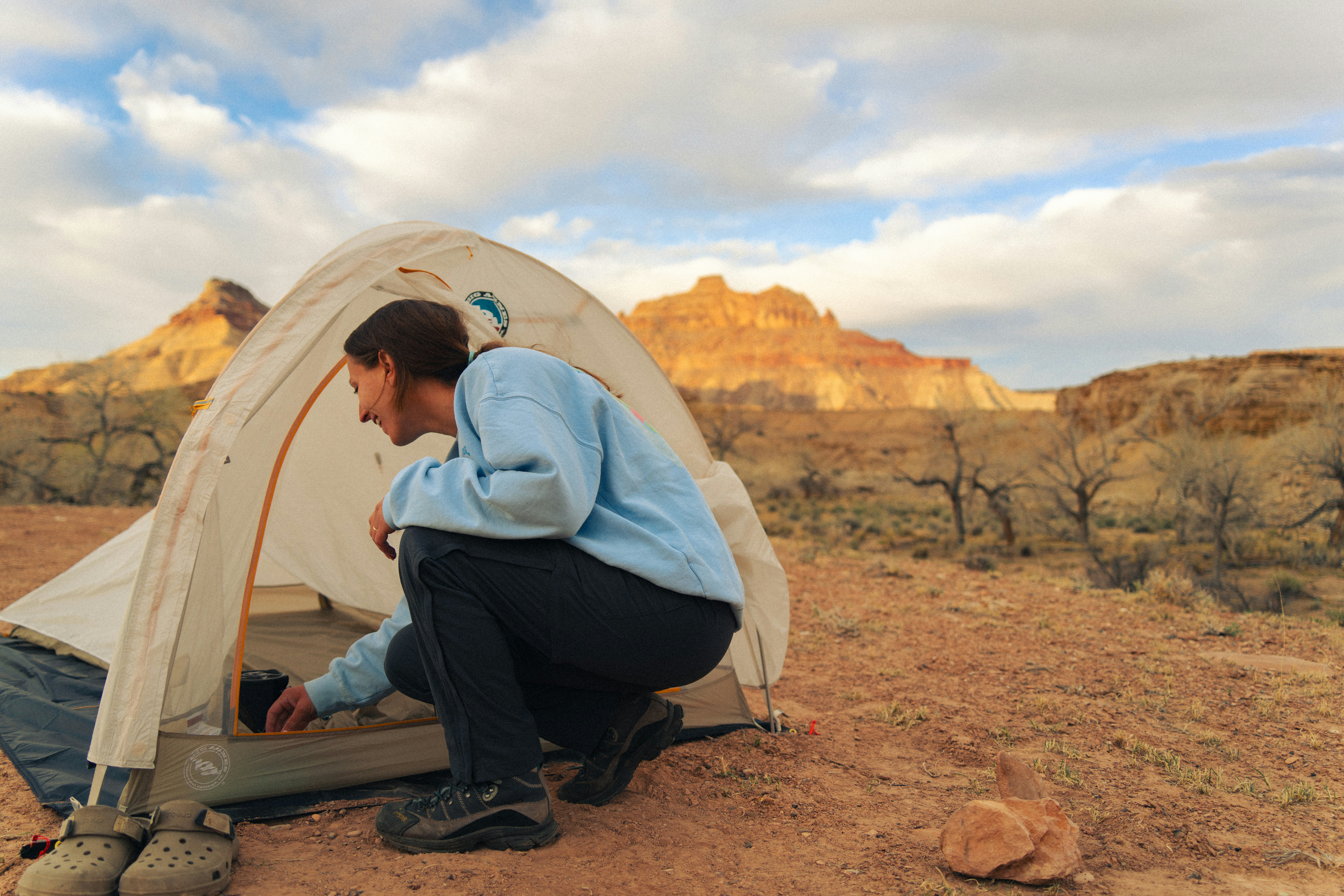 Woman setting up tent in desert landscape