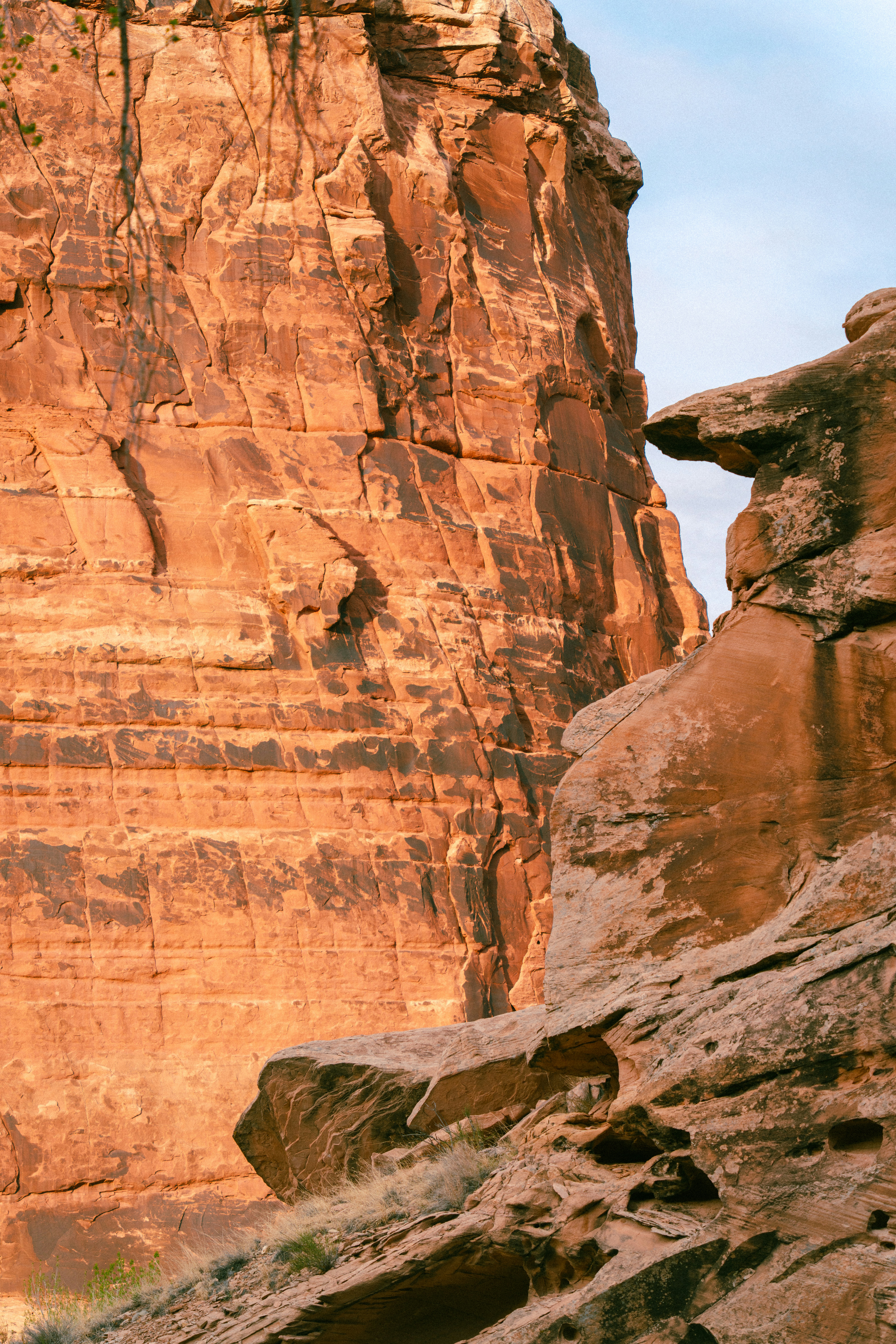 Red rock formations with layered textures under a bright sky