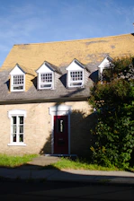 Brick house with dormer windows and red door