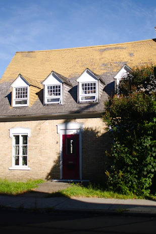 Brick house with dormer windows and red door