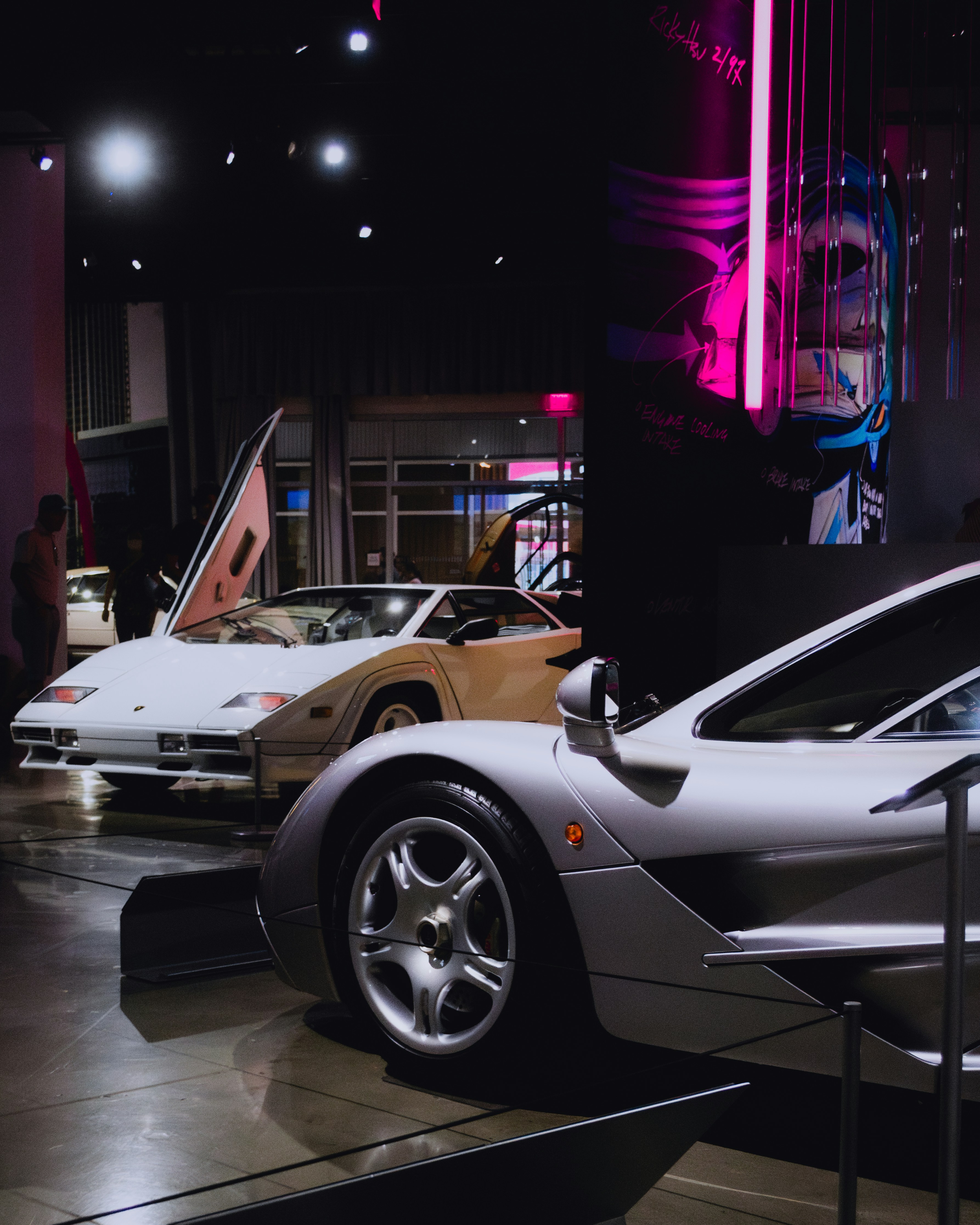 Klassische Sportwagen werden in einem schummrigen Showroom ausgestellt.