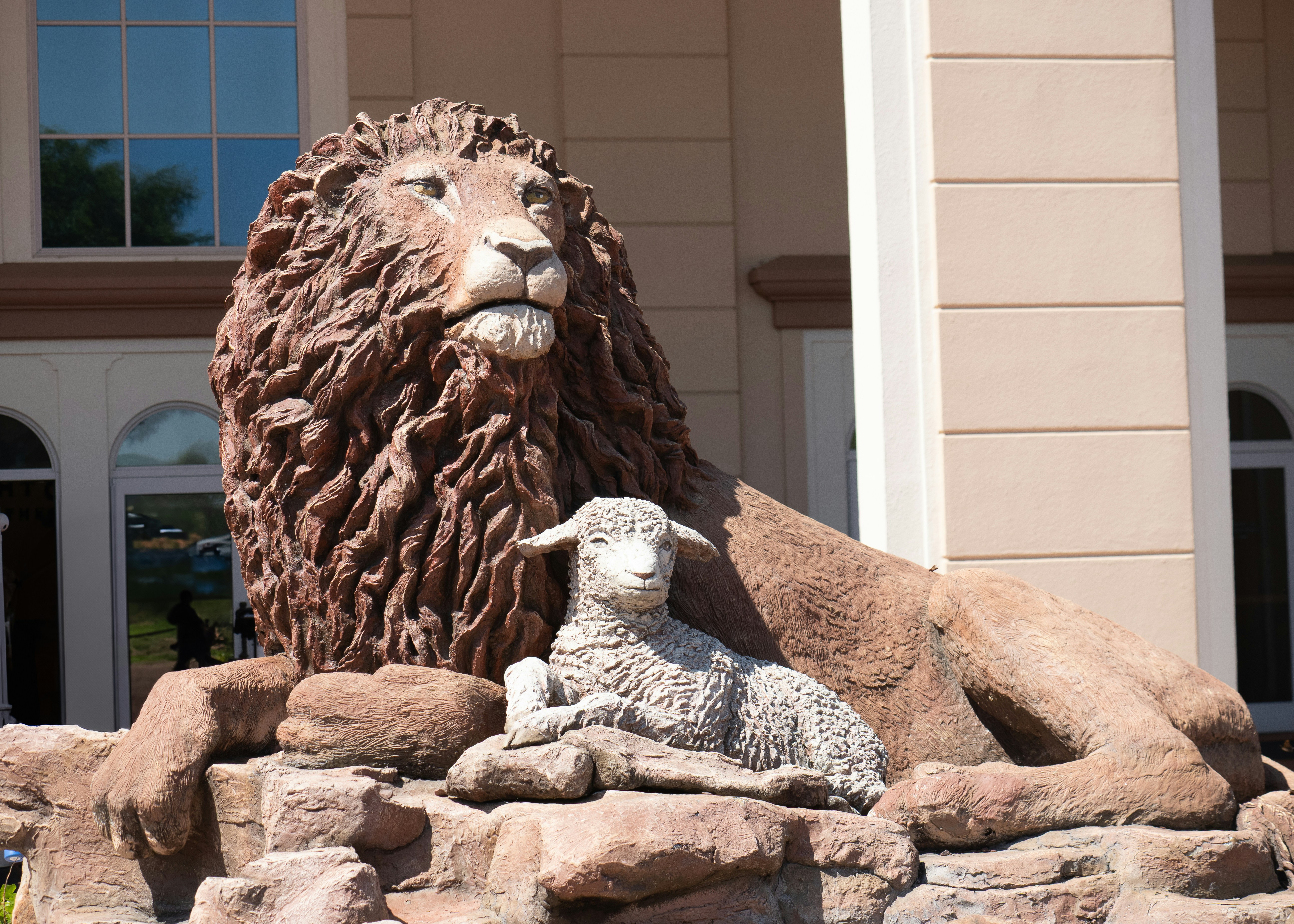 Lion and lamb sculpture outside building