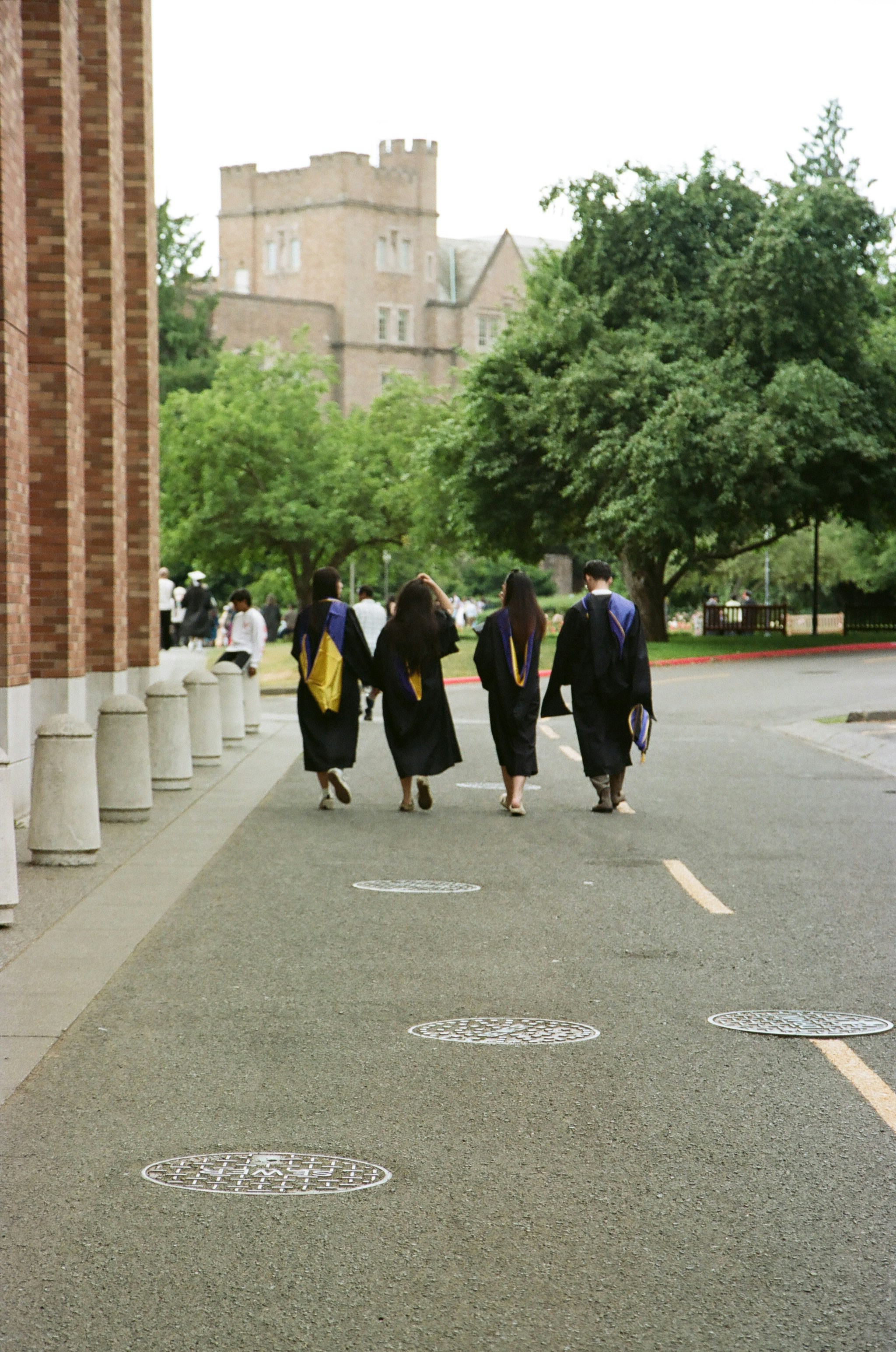 Graduates in caps and gowns walk on campus