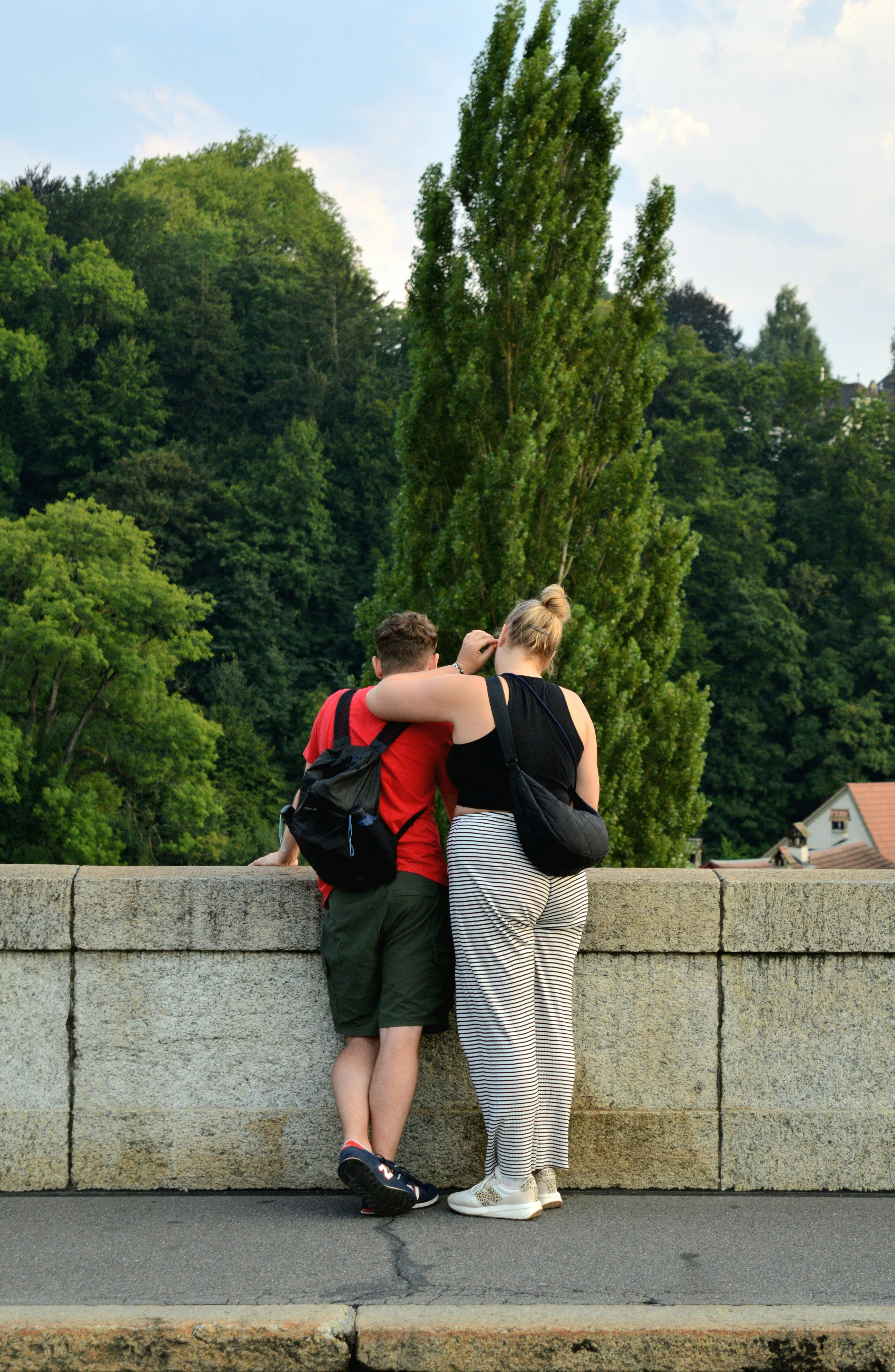 Couple embracing on a stone bridge with trees