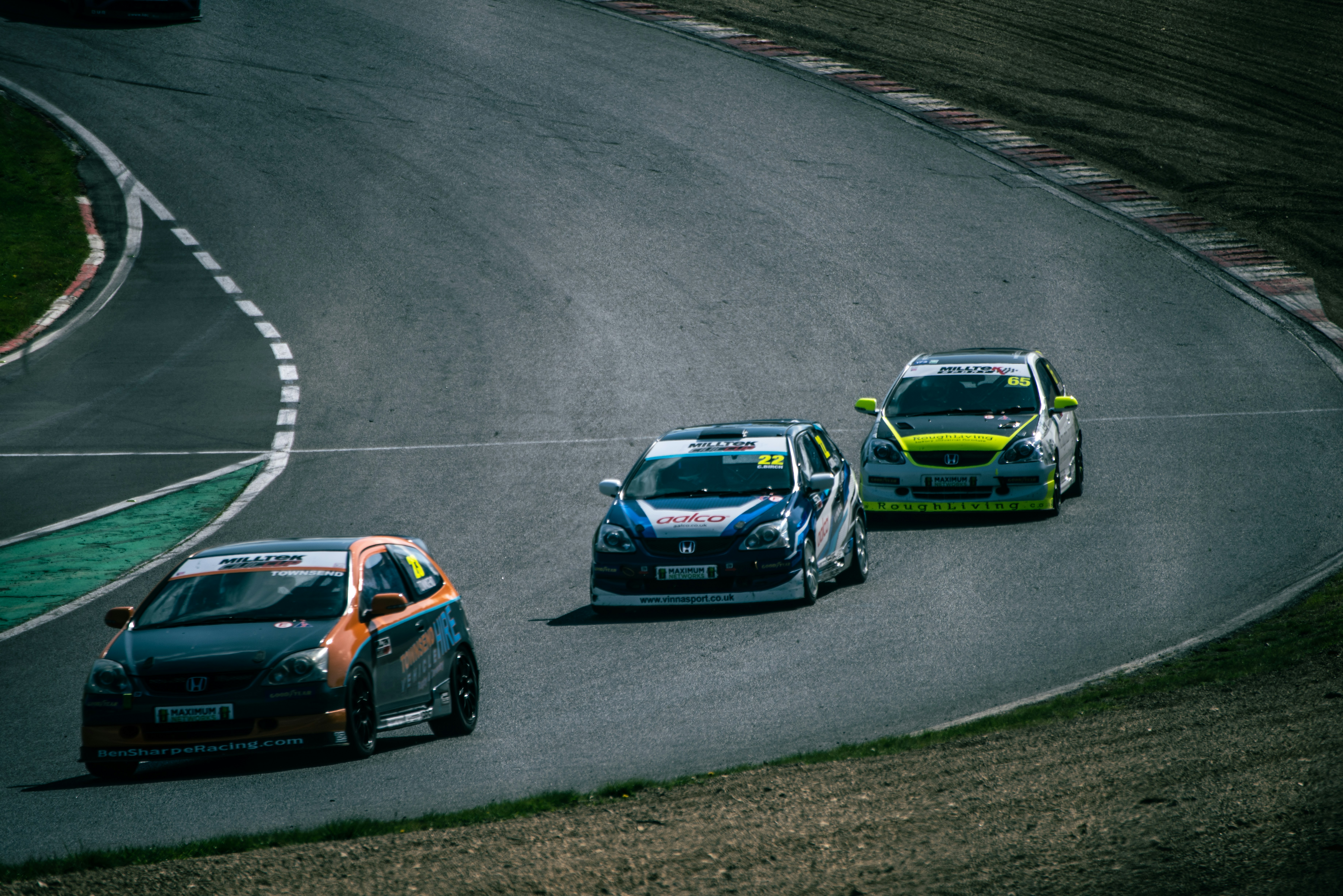 Three race cars competing on a winding track.