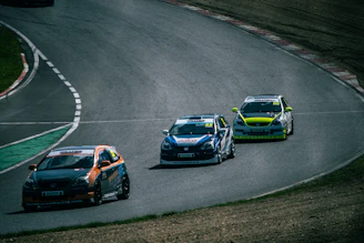 Three race cars competing on a winding track.