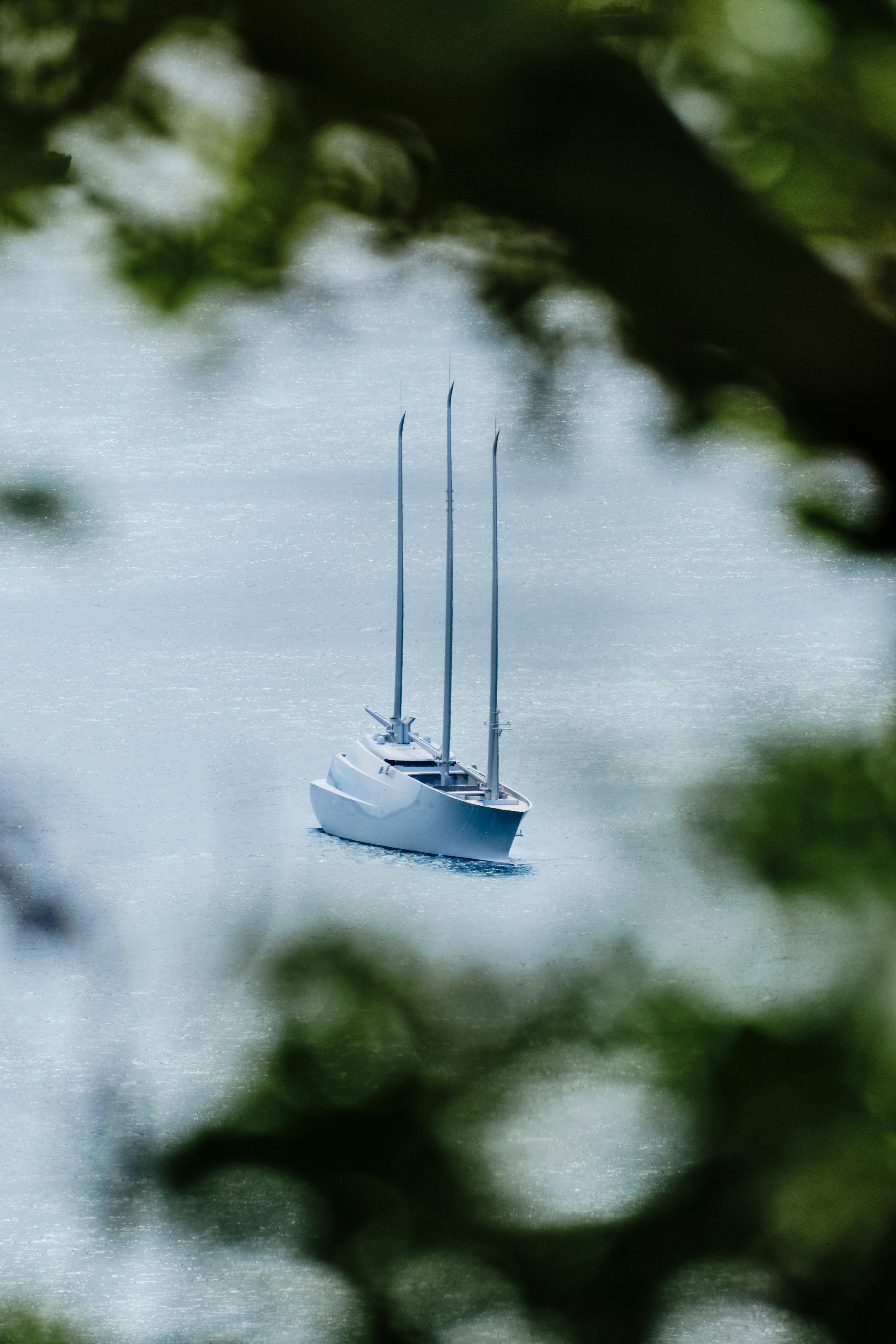 Modern sailboat with three masts on calm water.