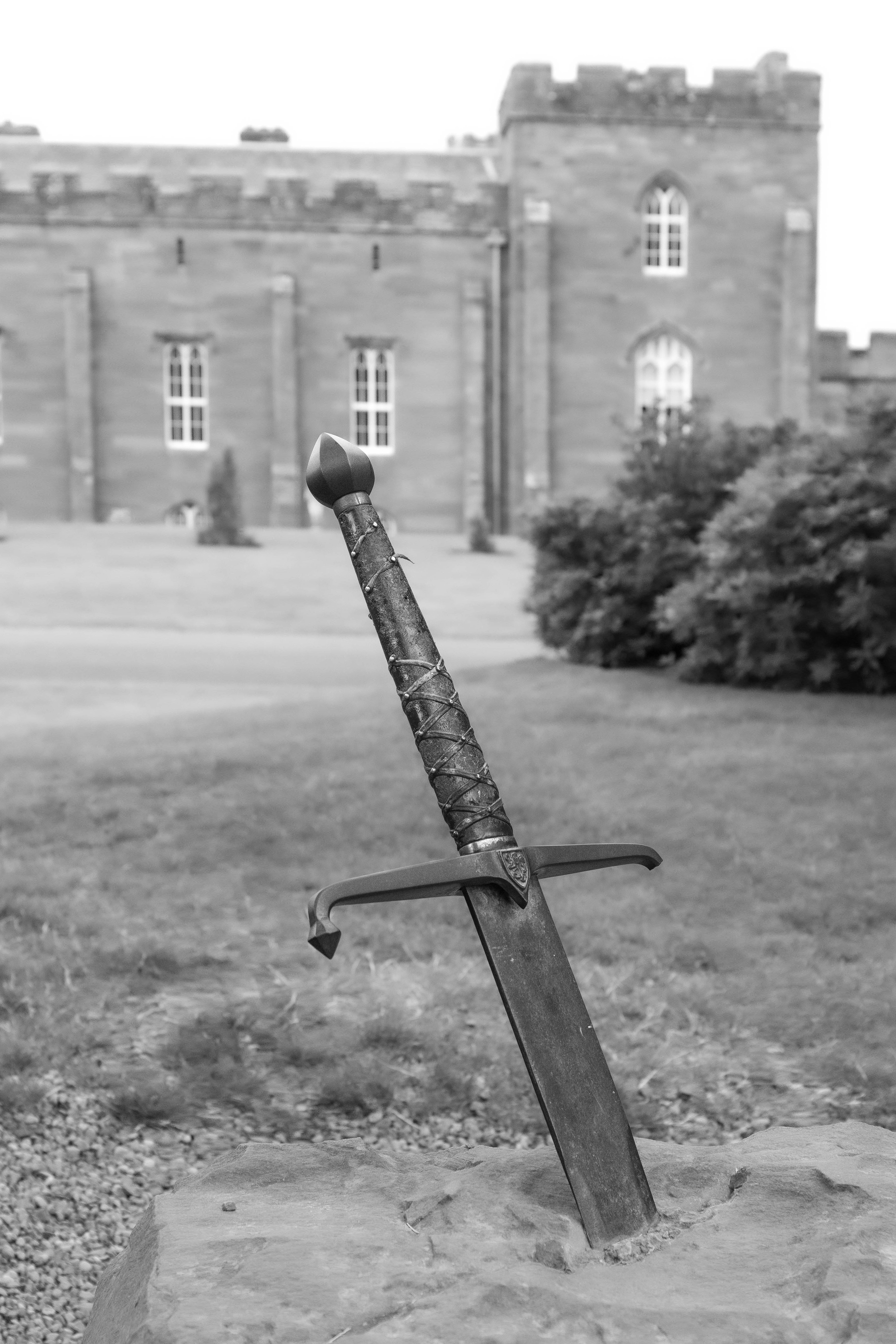 Sword stuck in stone with castle background