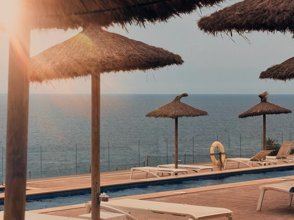 Hotel pool with sun loungers overlooking the sea
