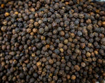 A close-up of dried black peppercorns