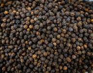 A close-up of dried black peppercorns