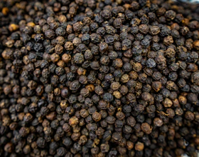 A close-up of dried black peppercorns