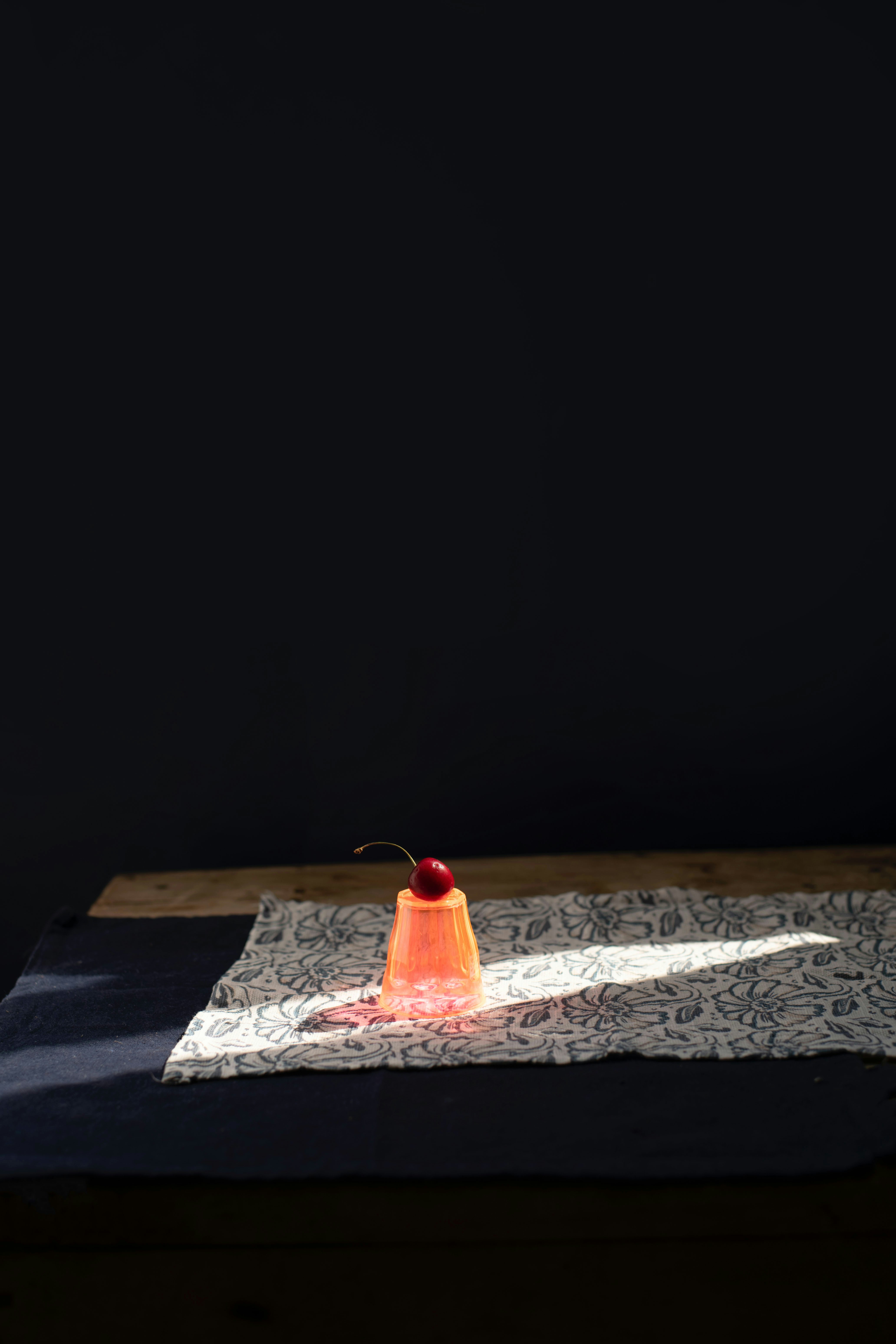 A single cherry atop a pink dessert