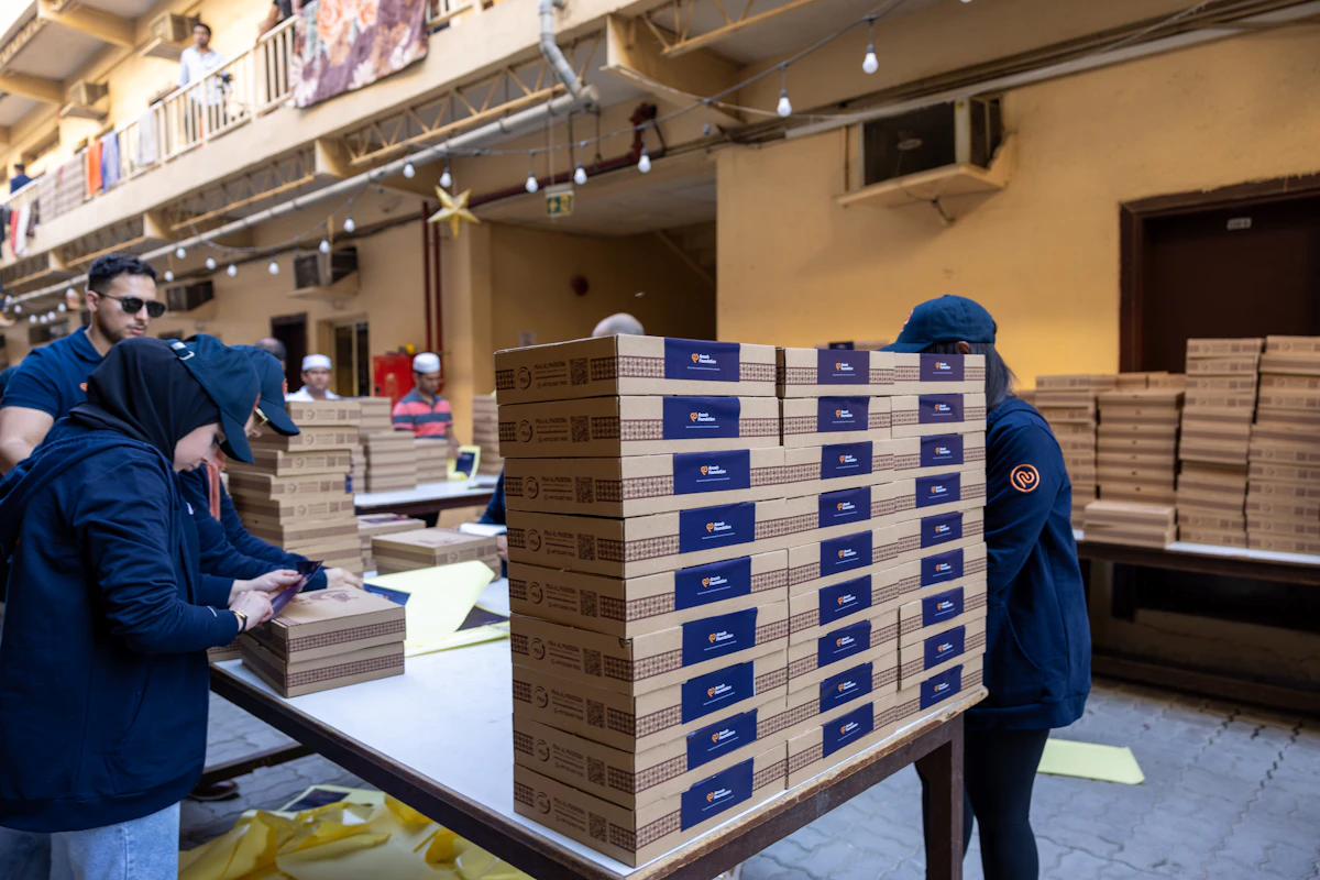 Warehouse team packing cartons for distribution