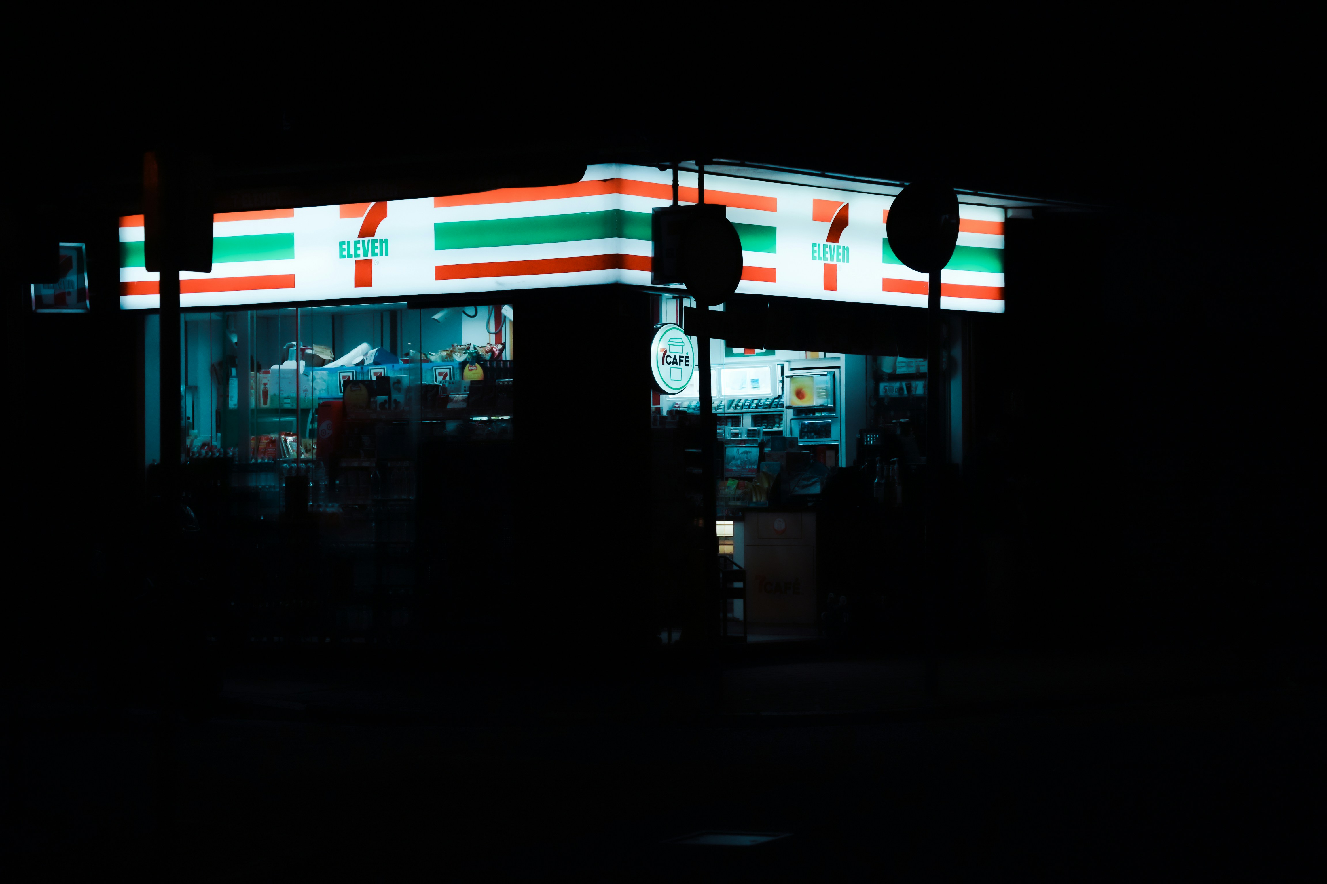 Convenience store illuminated at night on a dark street