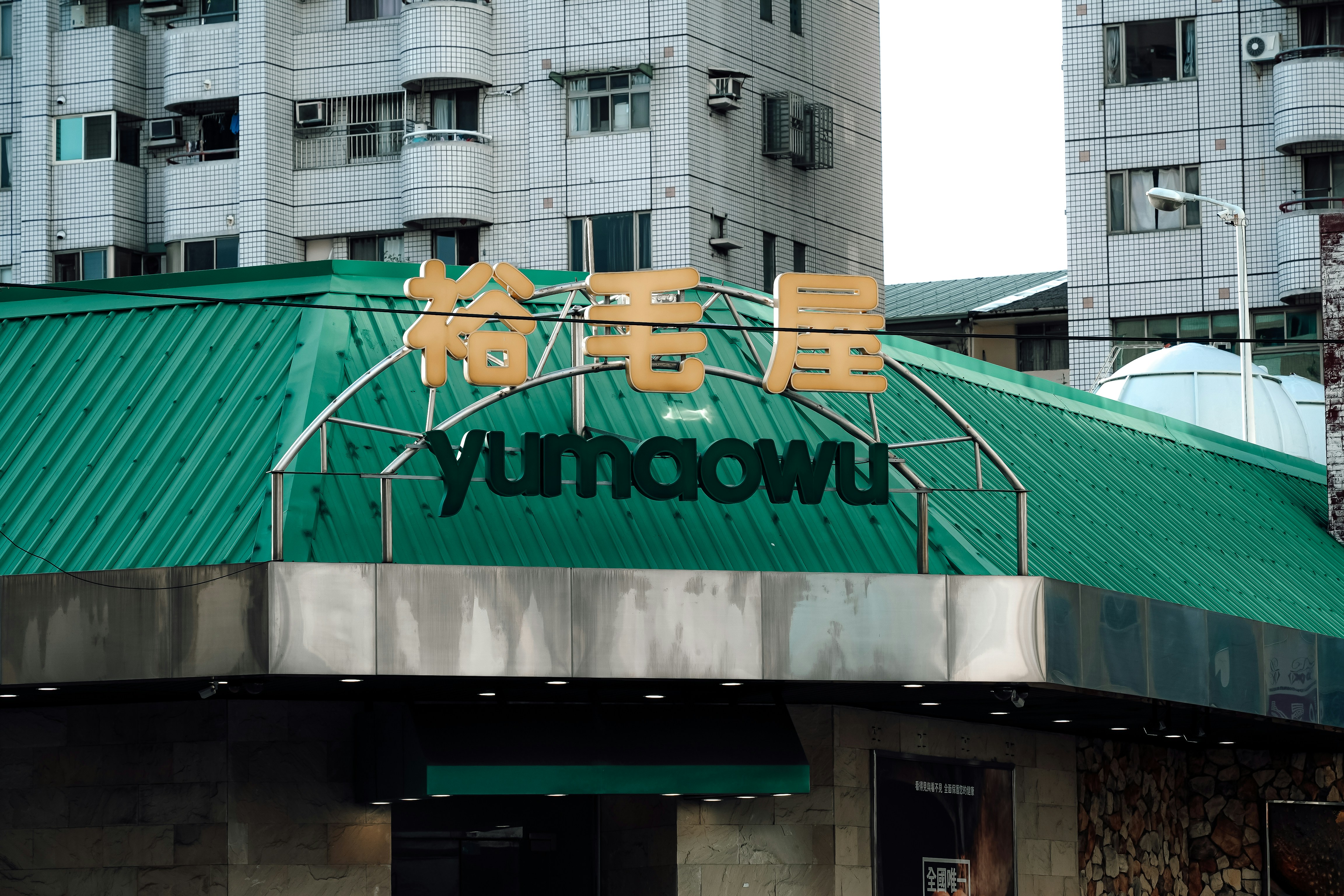 Green roof building with "yumaowu" sign