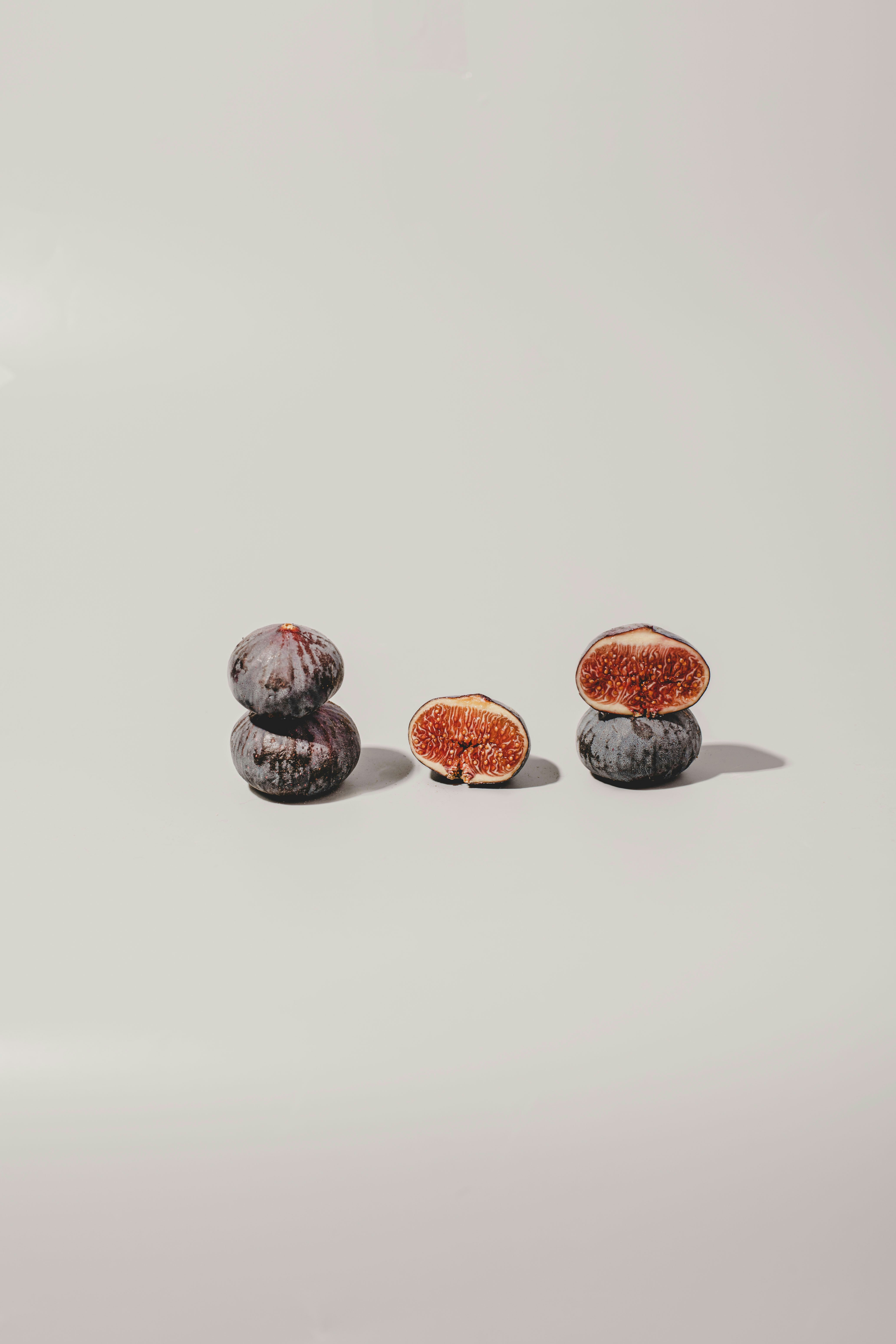 Two stacks of figs with one cut open