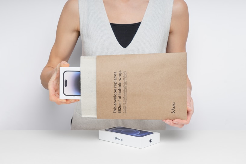 Person holding a new smartphone in packaging.