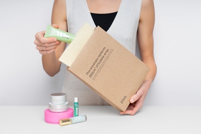 Woman placing skincare product into a package