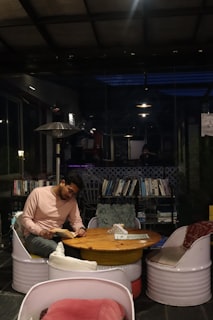 Personne lisant seule &agrave; une table de caf&eacute;, illustrant le besoin de calme propre &agrave; l'introversion