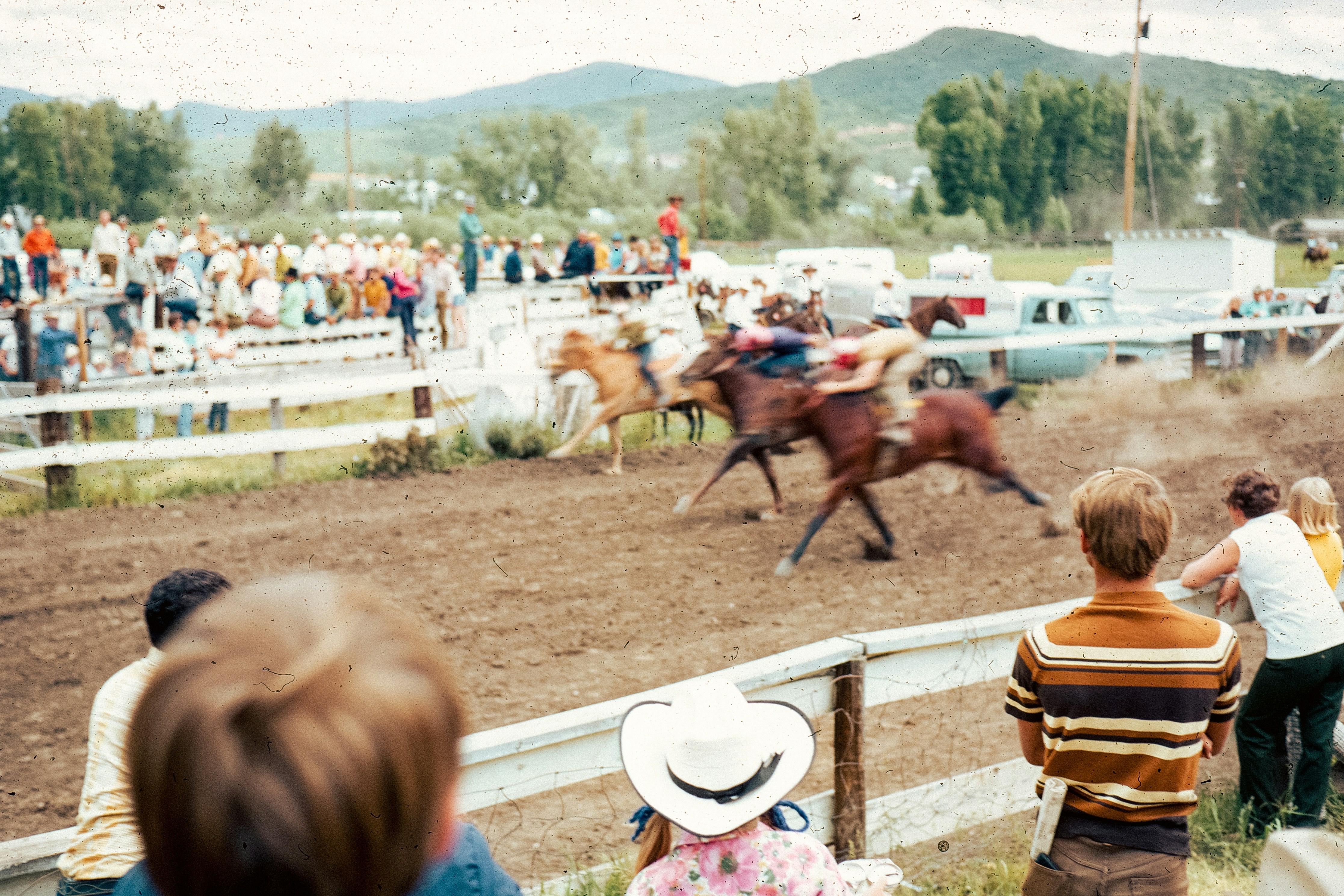 Horse race with spectators at a rural track.