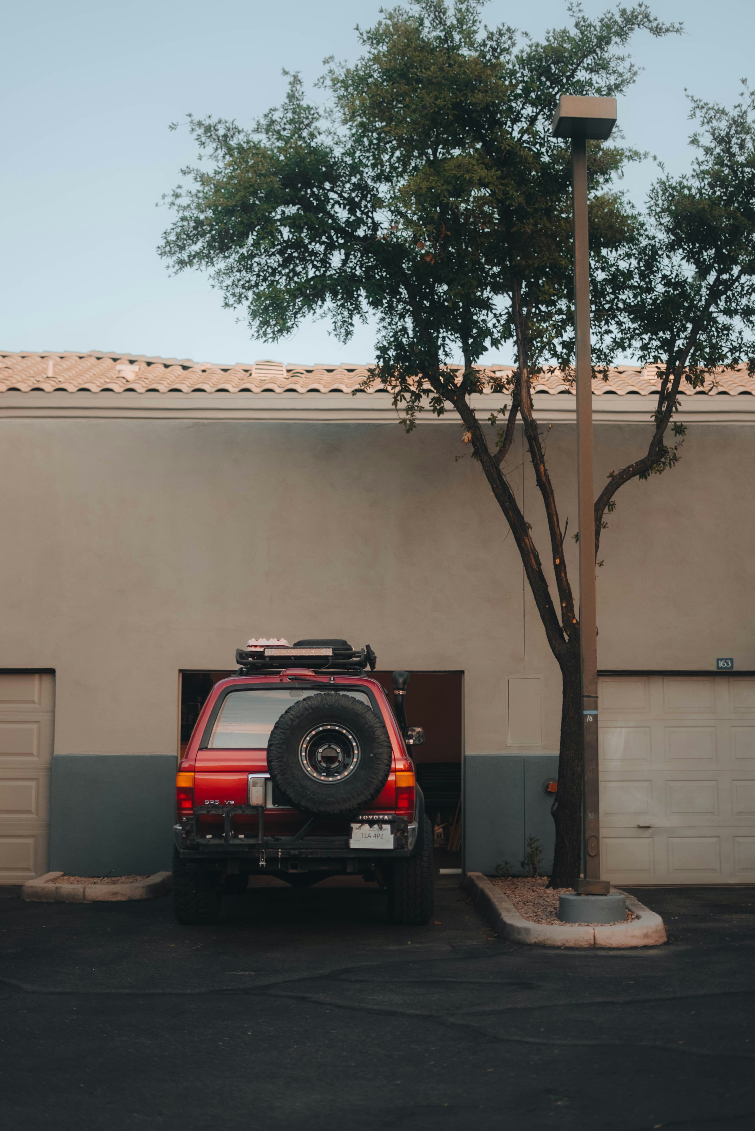 Red suv parked in front of a garage
