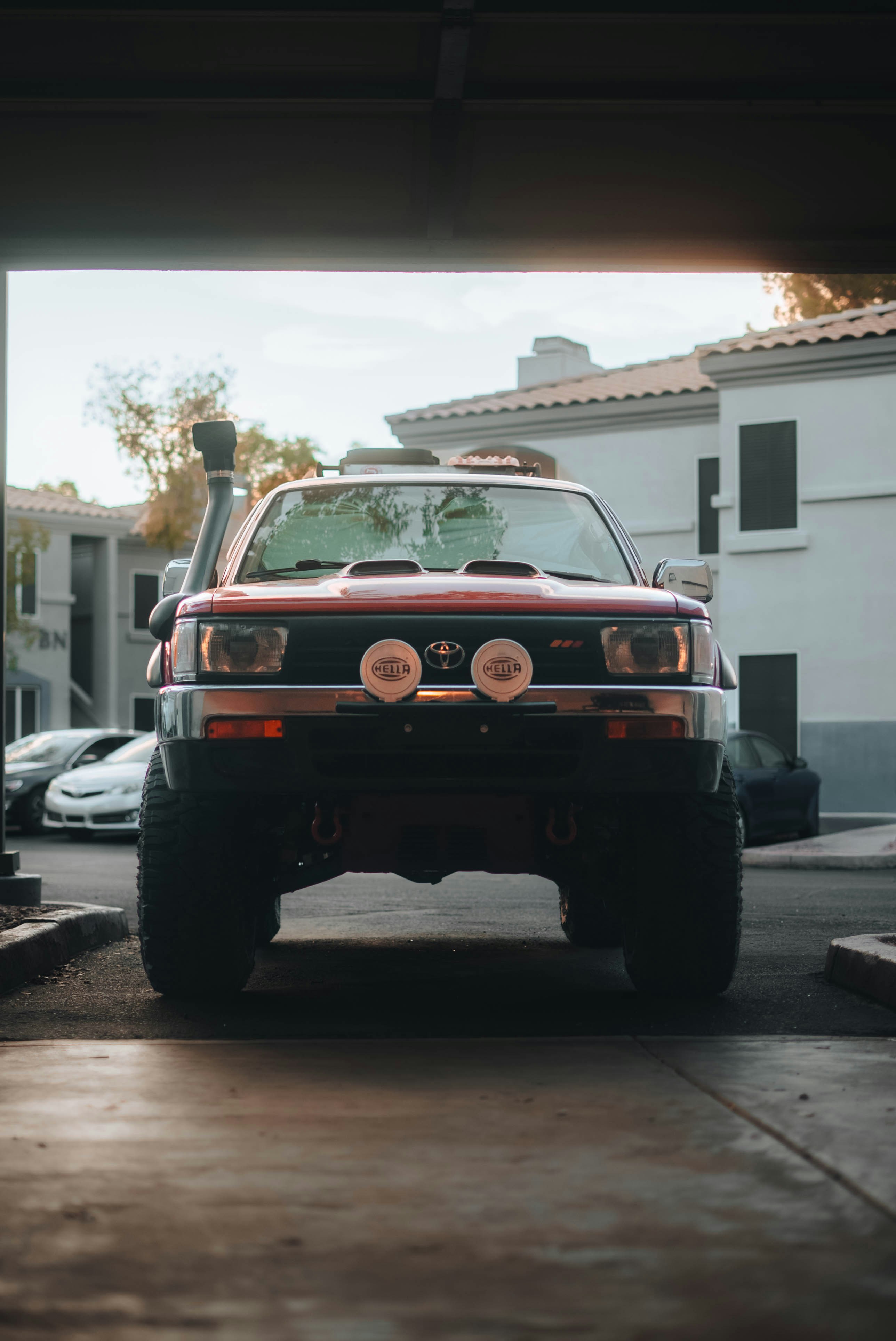 Red off-road vehicle with snorkel and spotlights.