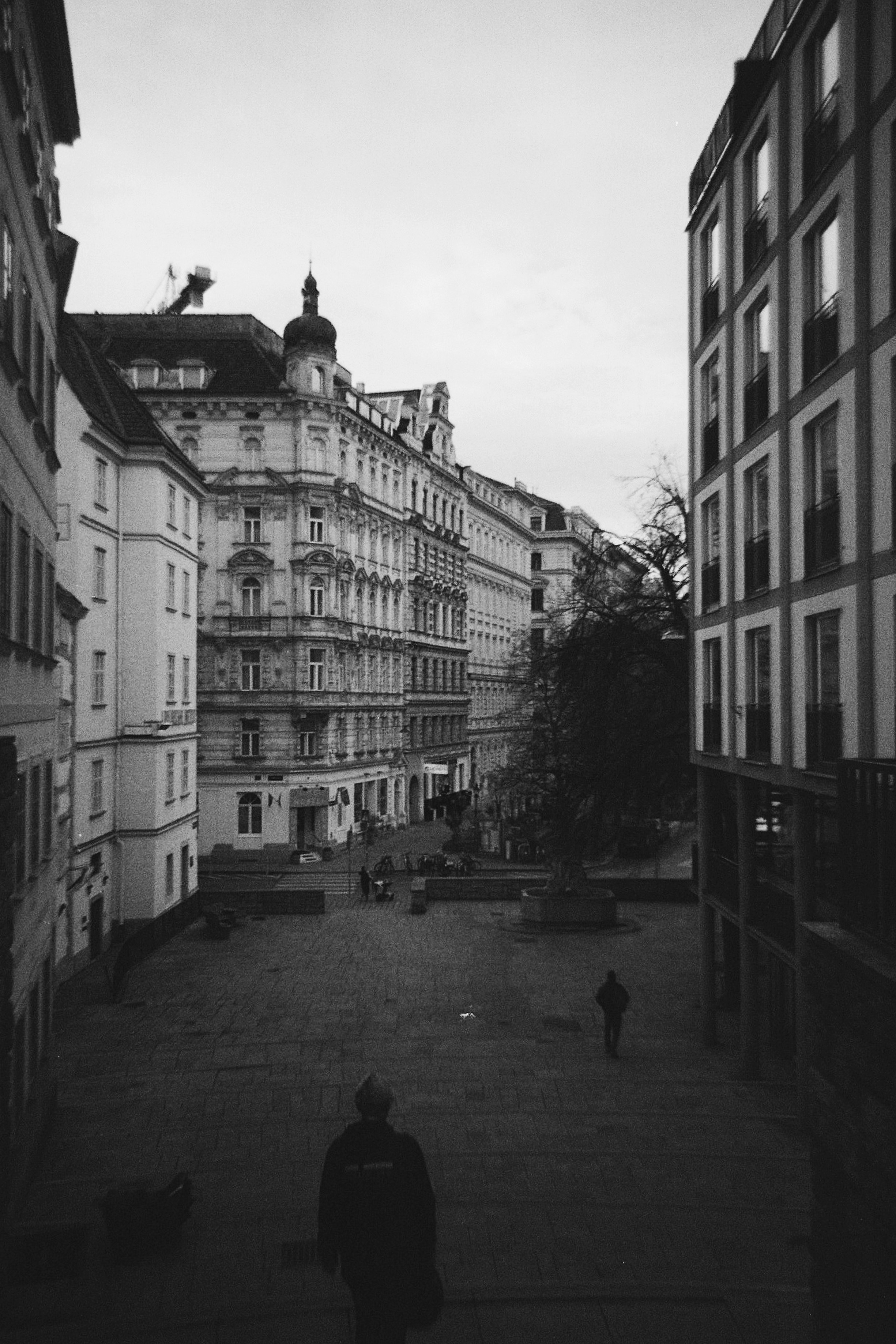 People walk through a european city square.