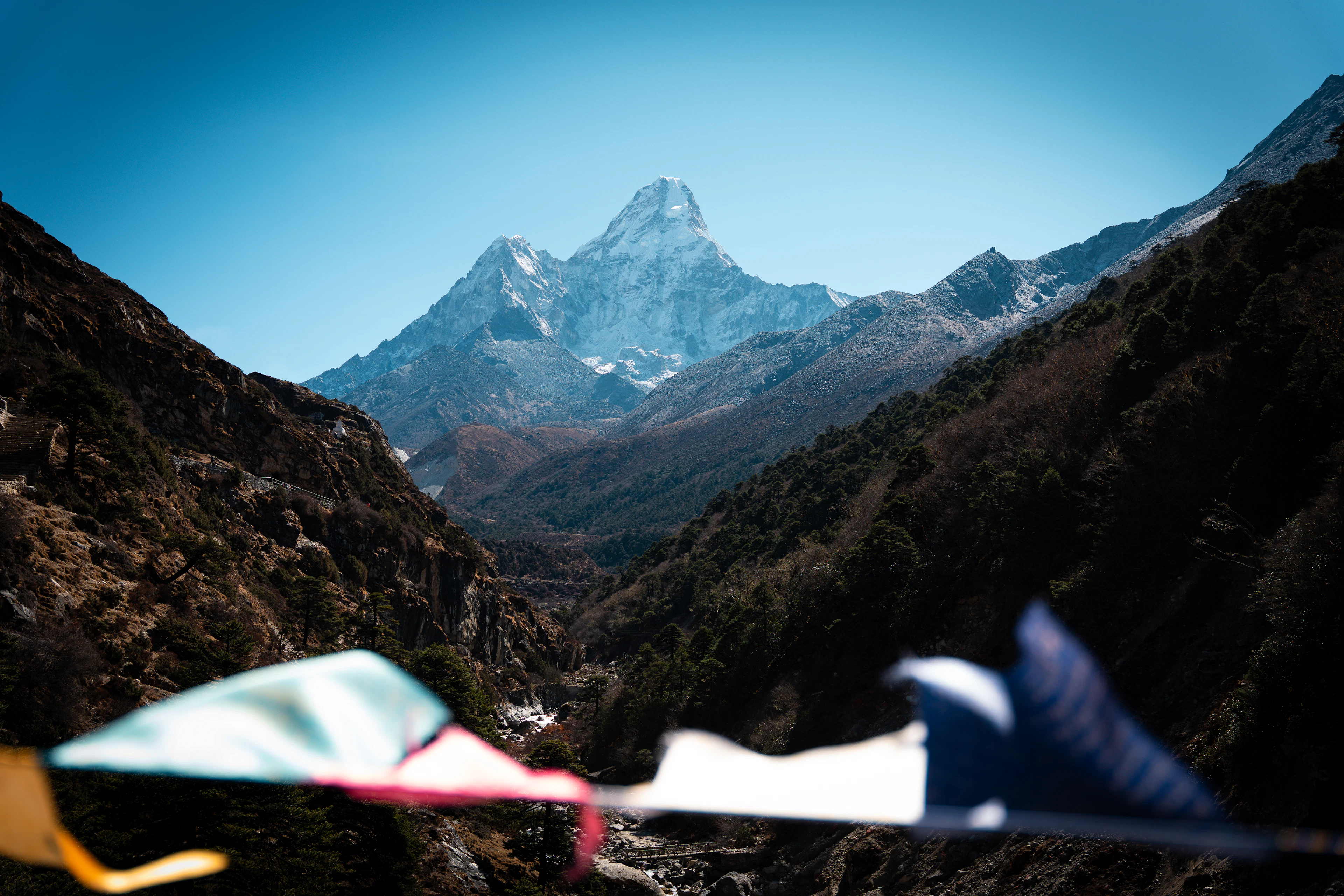 Ama Dablam viršūnė virš slėnio, priekyje plazda maldos vėliavėlės, Everesto regionas