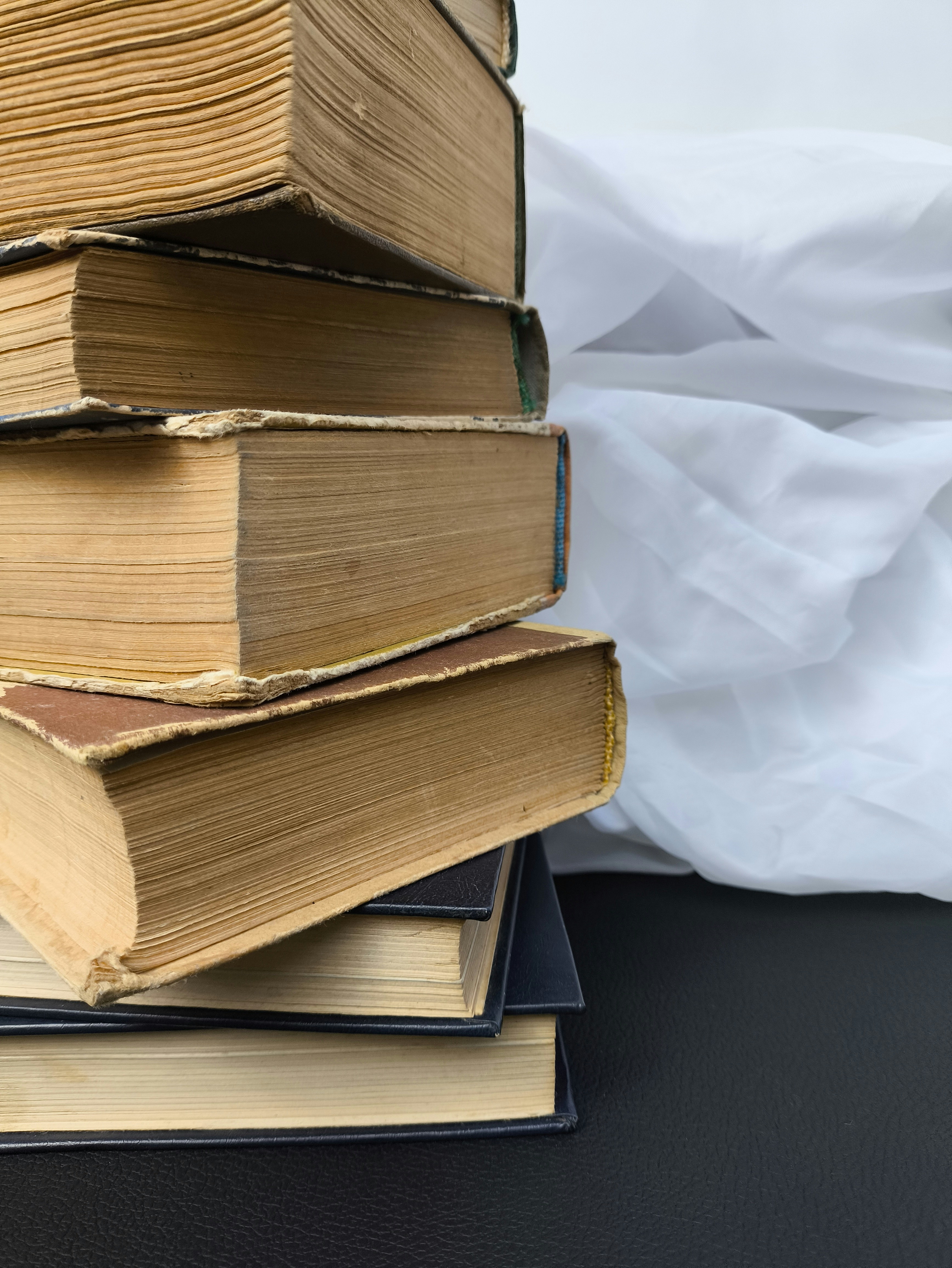 Stack of old books with worn pages and covers