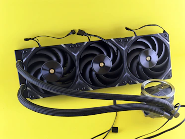 Black computer fan cooler with tubes on yellow background