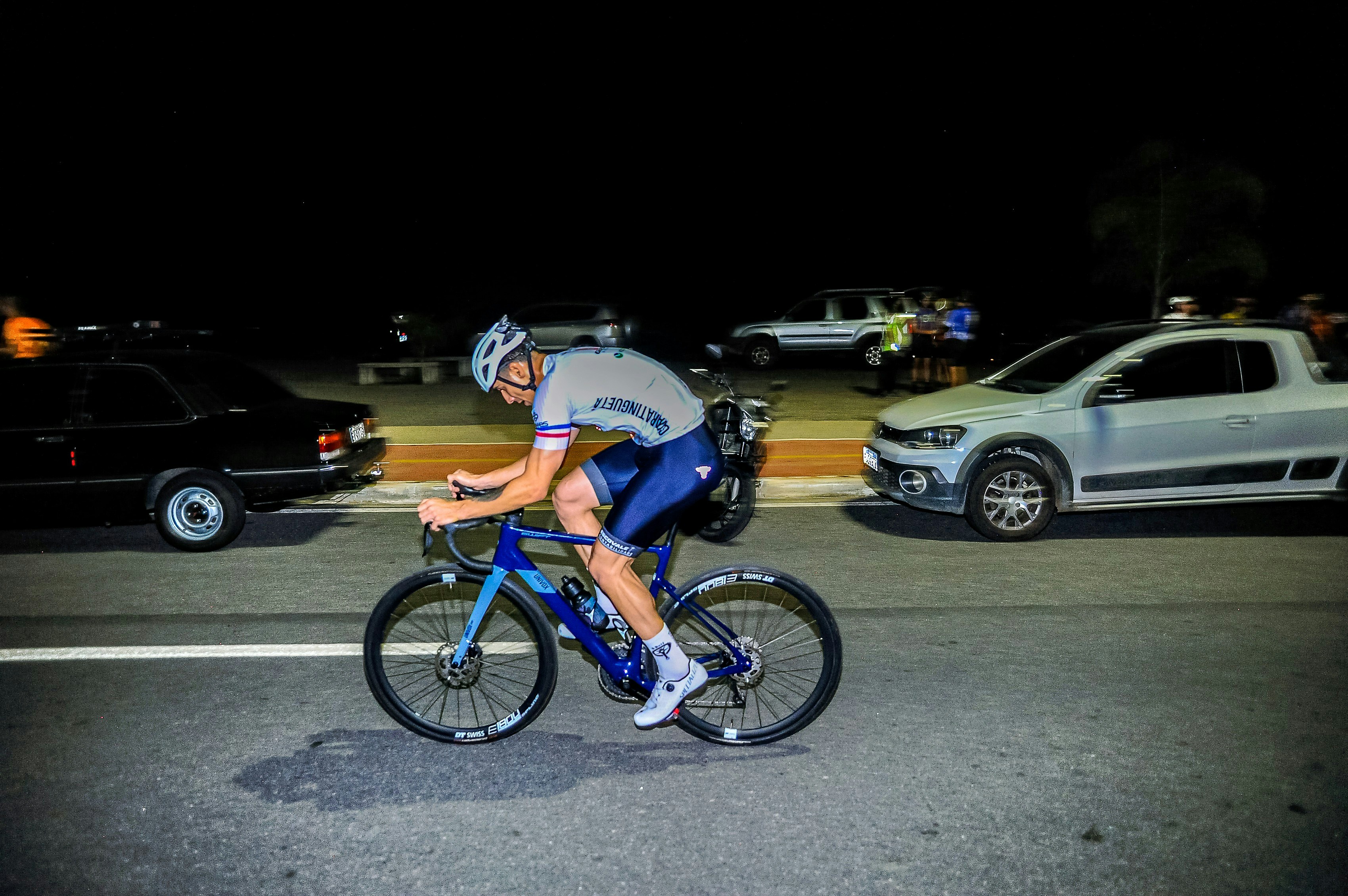 Cyclist rides a bike on a street at night.