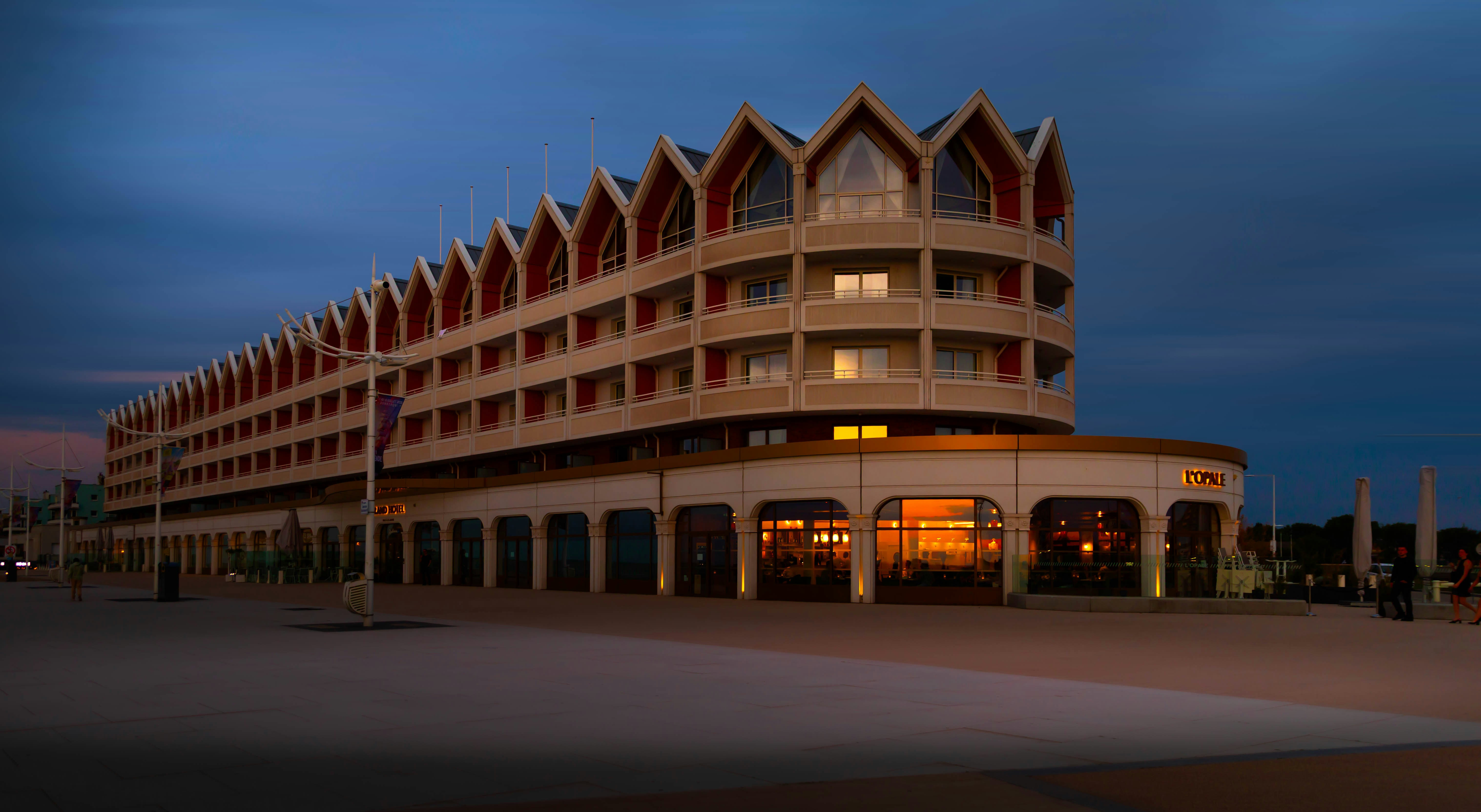 Modern building with distinctive crown-like roof at dusk