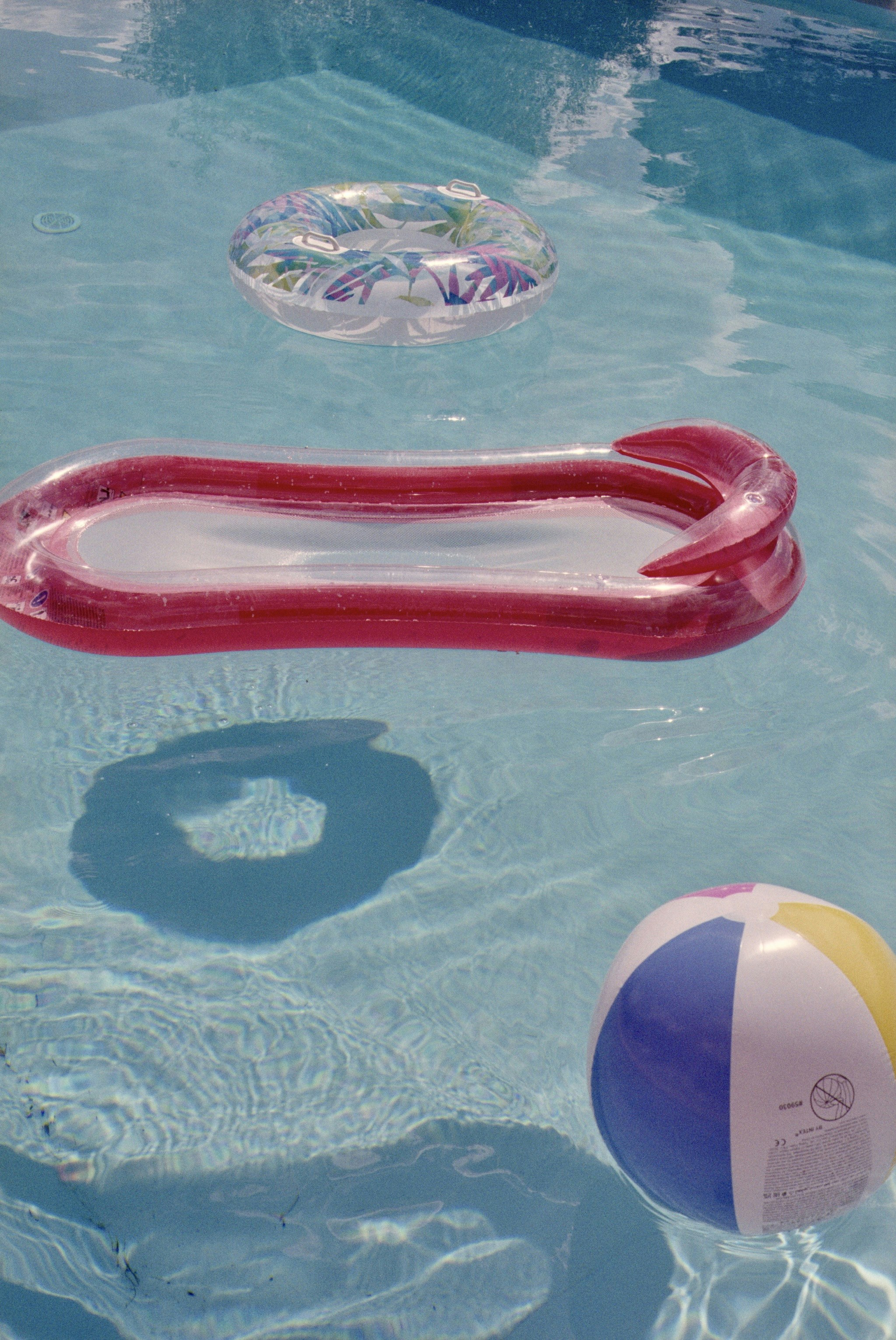 Inflatable pool toys float in clear blue water