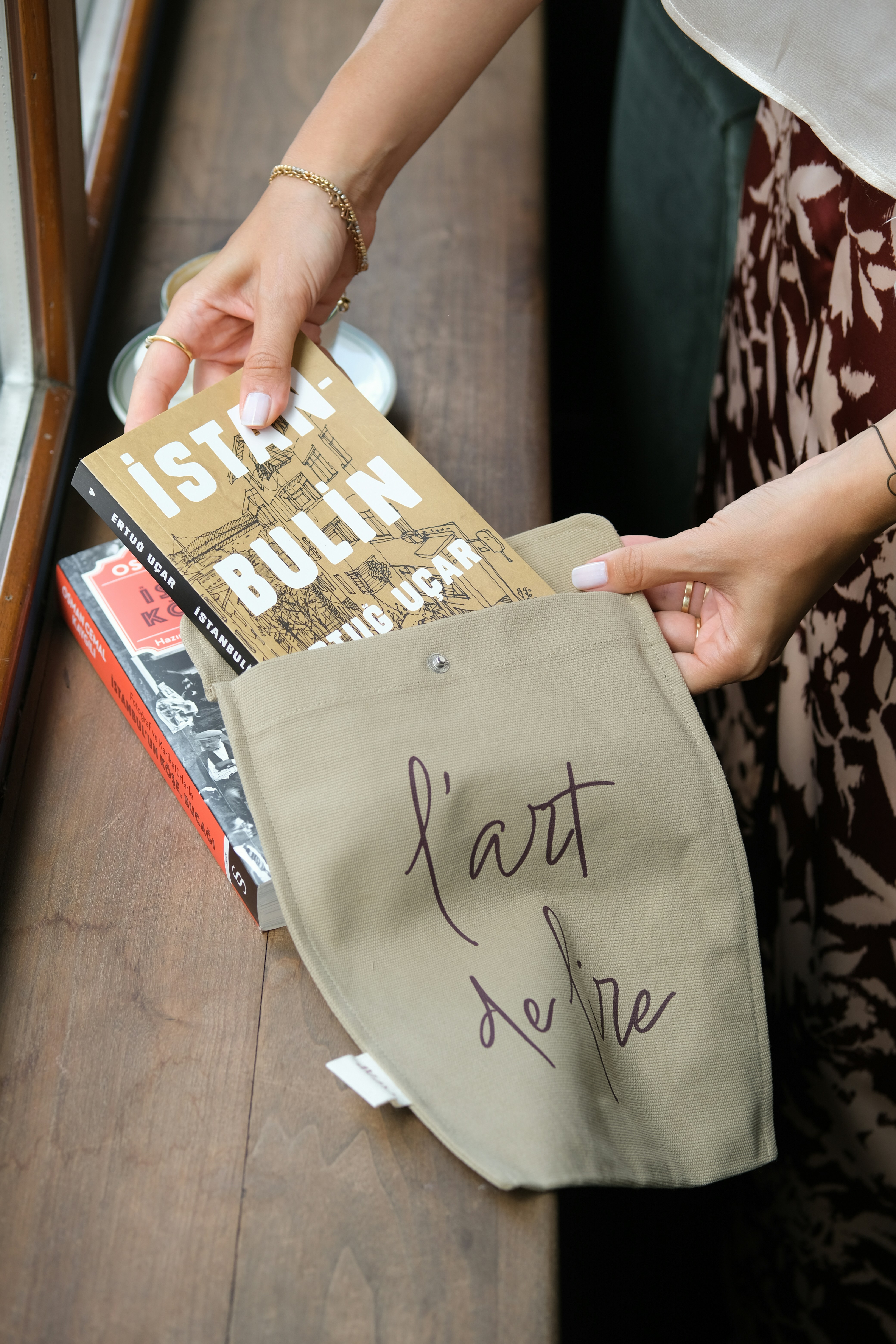 Woman placing books into a canvas tote bag