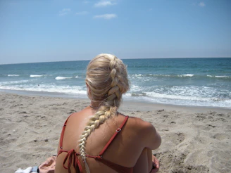 Woman with braided blonde hair on sandy beach