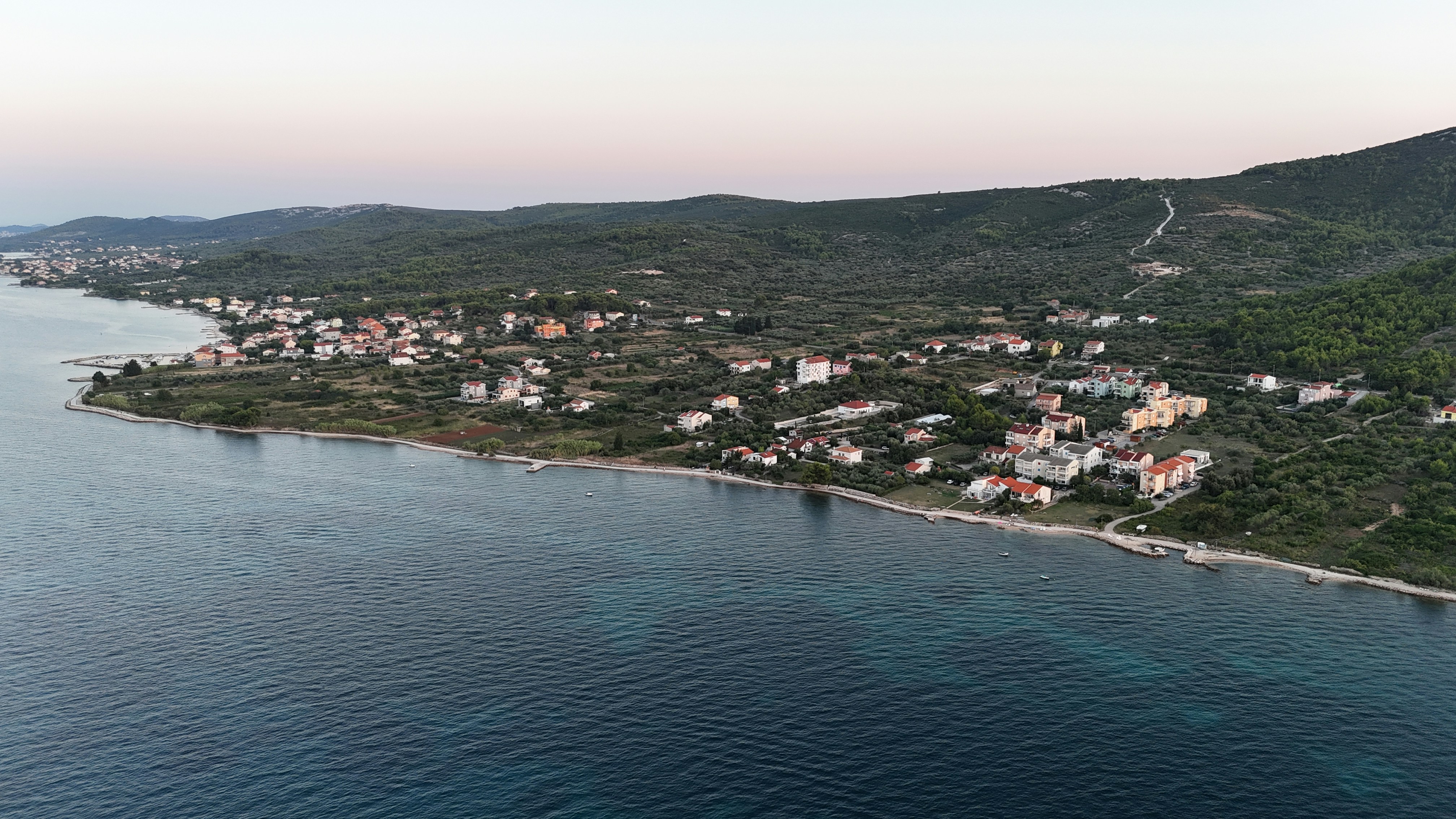 Coastal village nestled beside a calm blue sea.