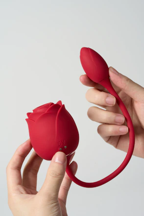 Red rose-shaped object held by hands